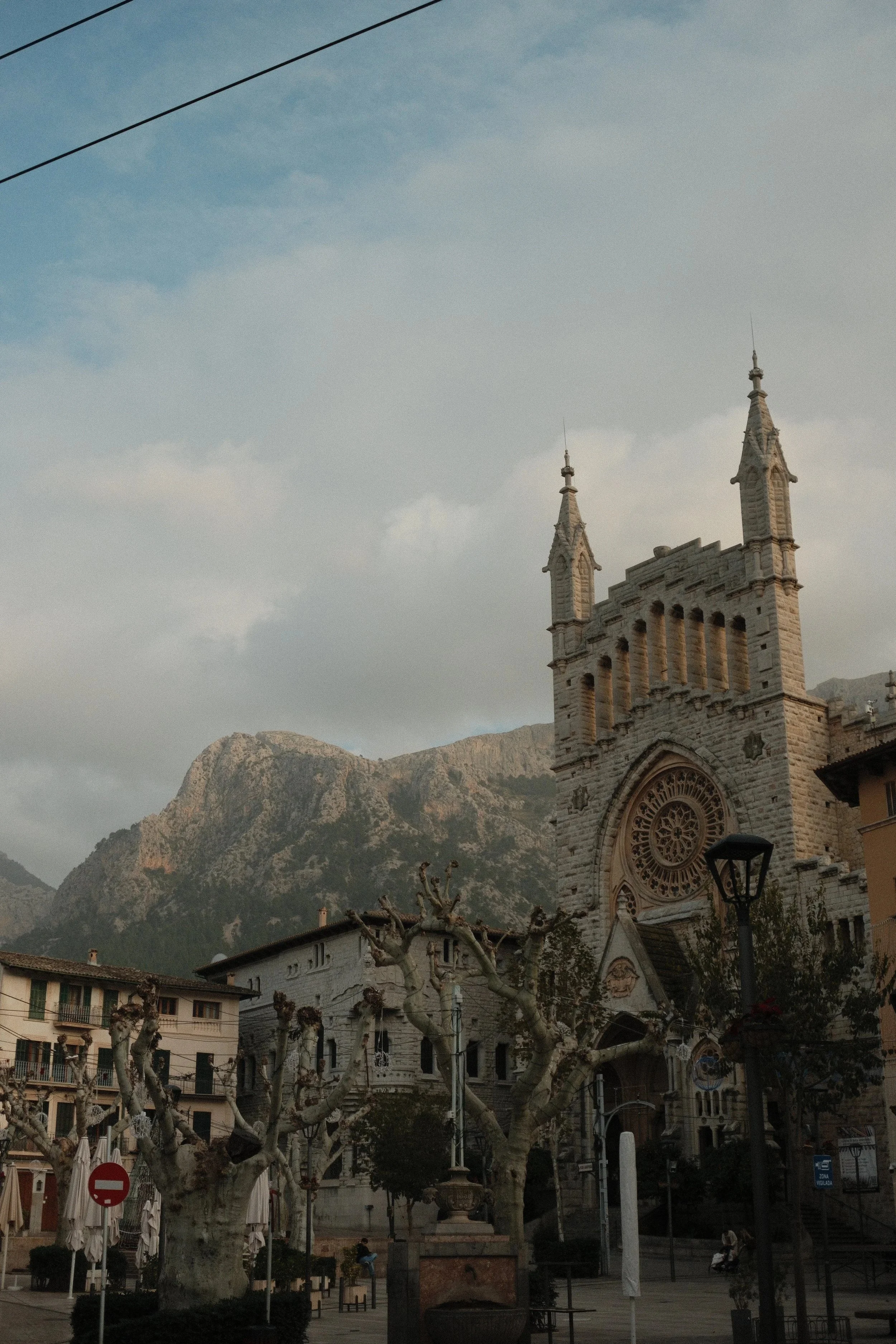 Neo-Gothic church tower below the Serra de Tramuntana mountains, Mallorca, Spain, by Zyan Sachs