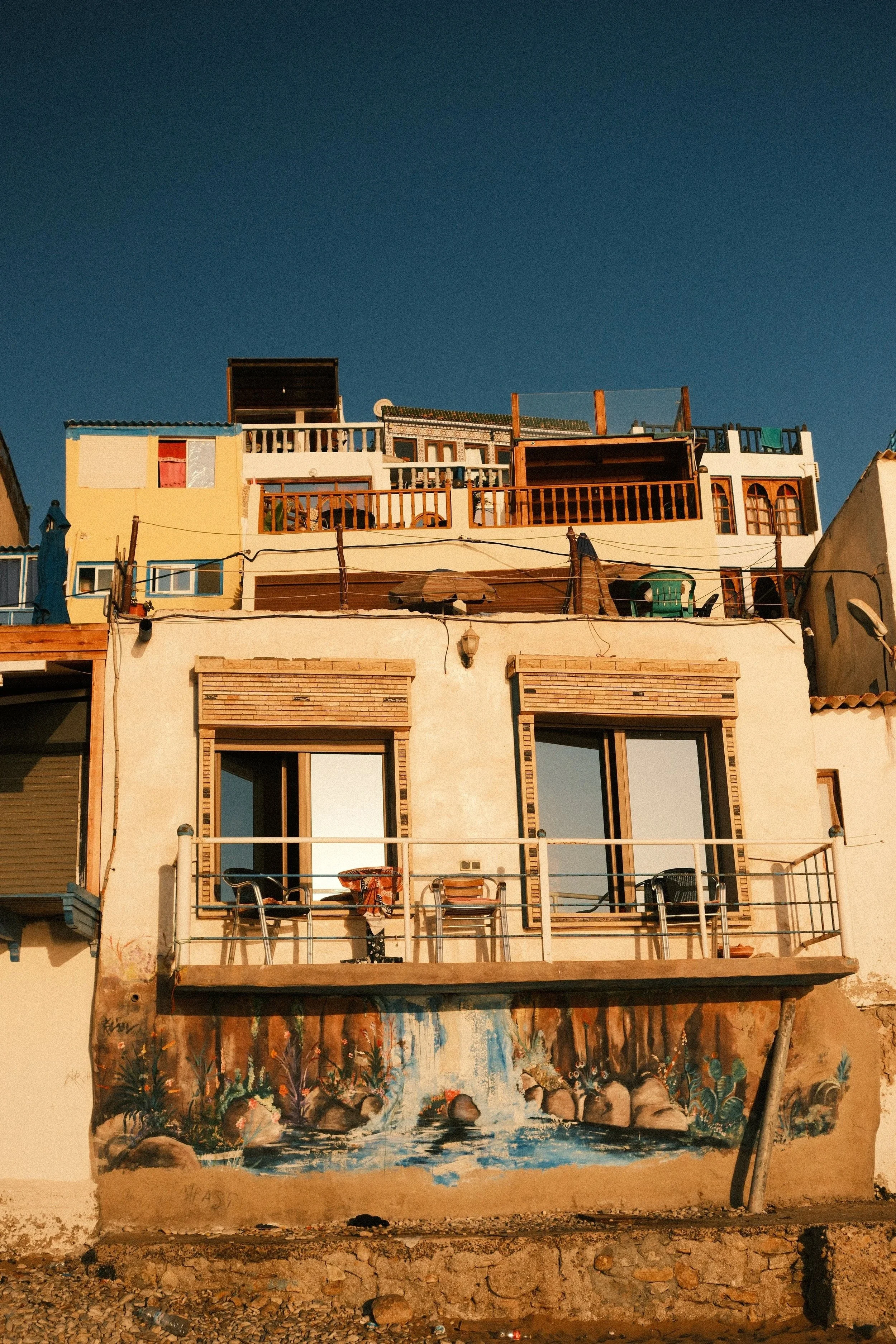Balconied apartment building glowing in late afternoon light, Taghazout, Morocco - fine art print by Zyan Sachs