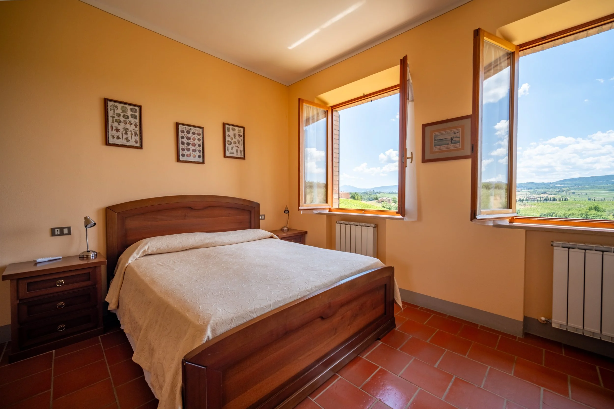 Double bedroom with wooden furniture and a countryside window at Agriturismo Metina, Montepulciano, Tuscany, by Zyan Sachs