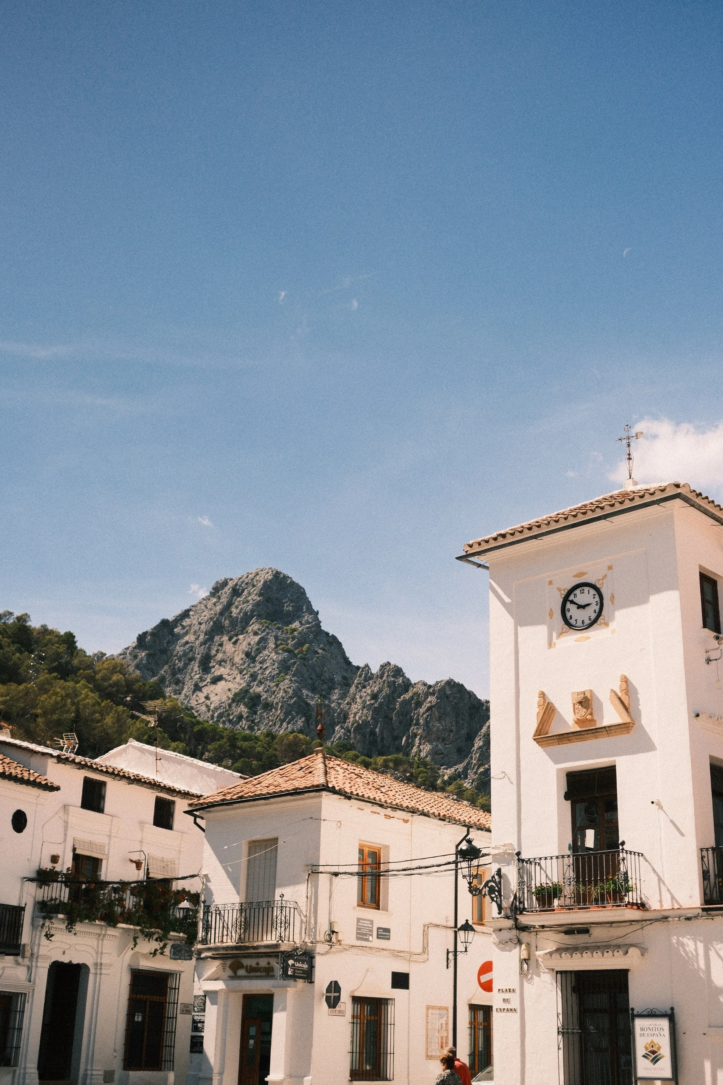White houses of Grazalema below a jagged mountain peak, Andalusia, Spain - fine art print by Zyan Sachs