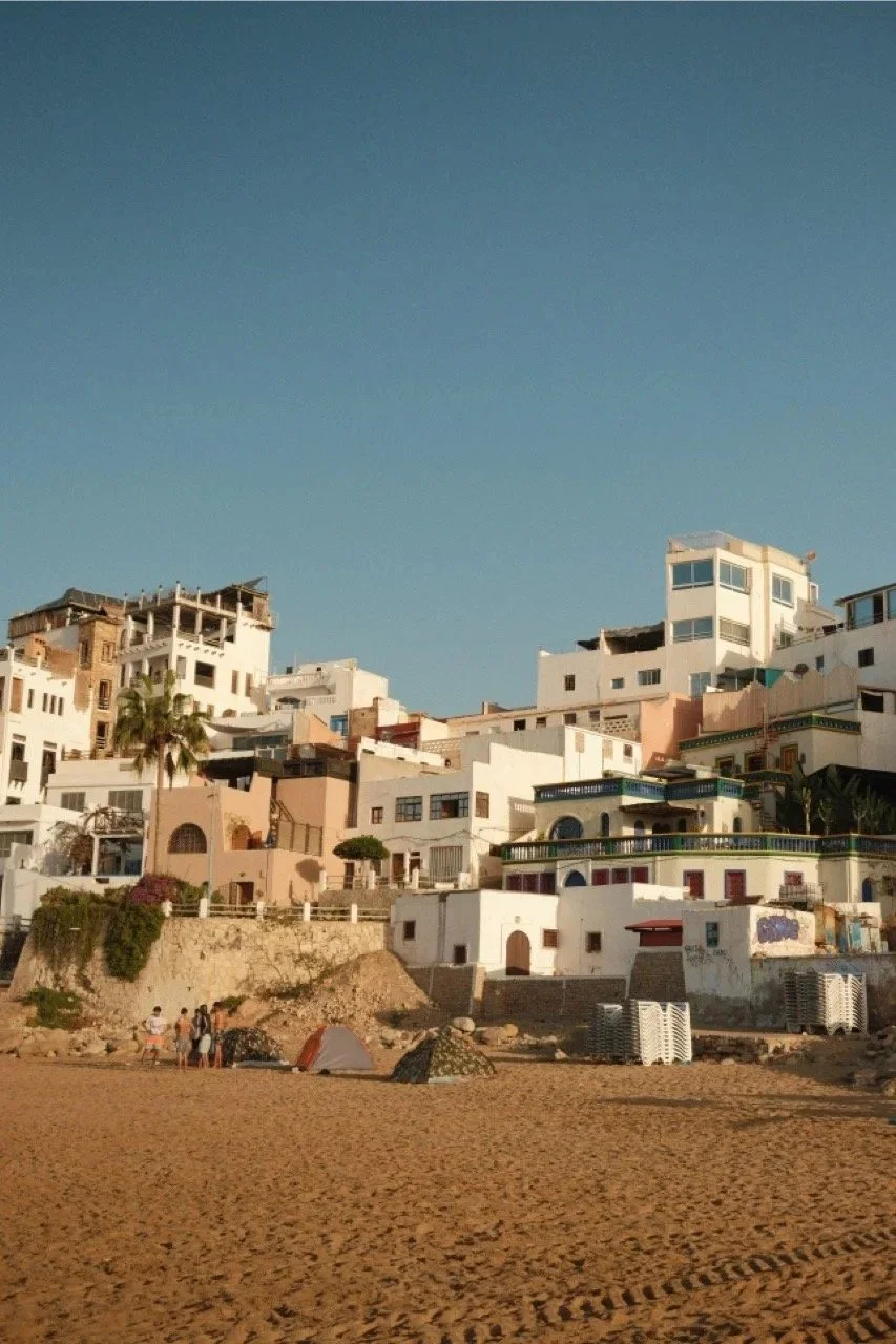 Hillside houses above the beach in golden light, Taghazout, Morocco - fine art print by Zyan Sachs