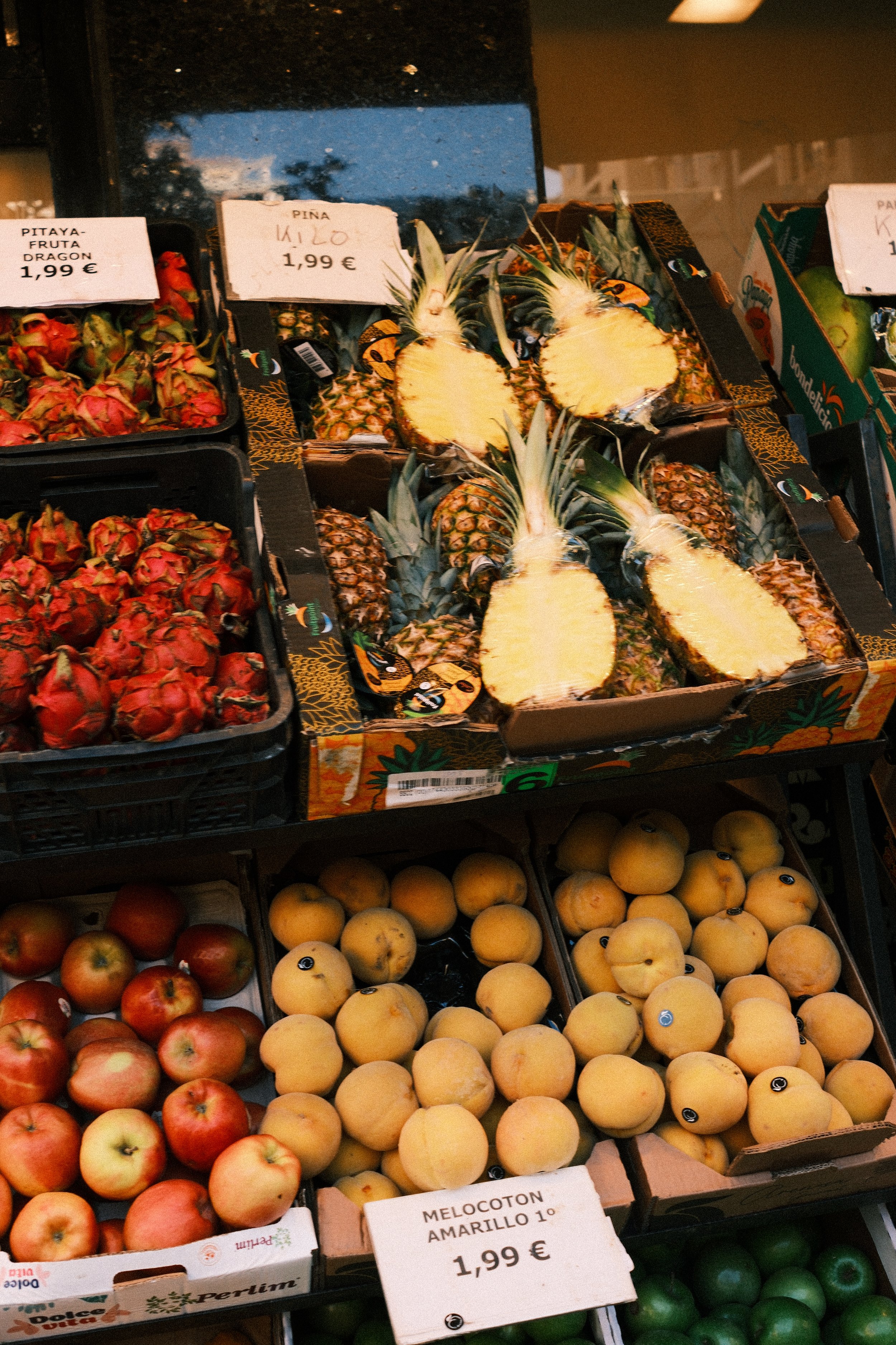 Crates of pineapples, apples and strawberries at a fruit market, Basque Country, Spain, by Zyan Sachs