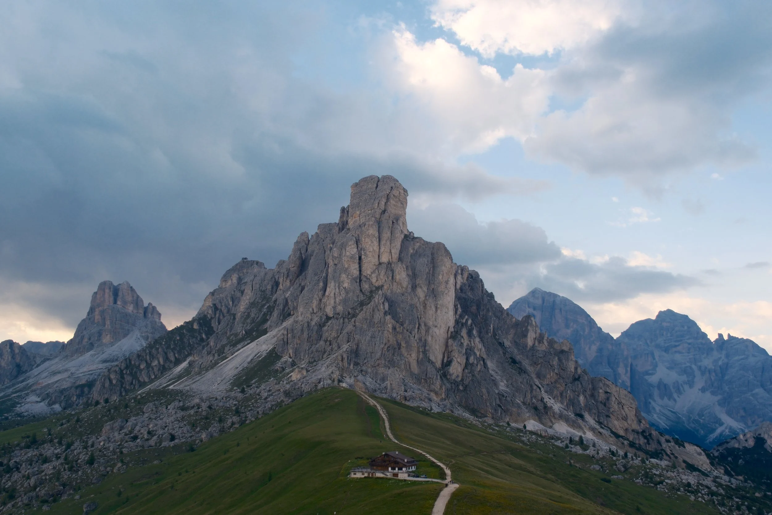 Ra Gusela peak above the rifugio and footpath at Passo Giau under dramatic clouds, Dolomites, Italy, by Zyan Sachs
