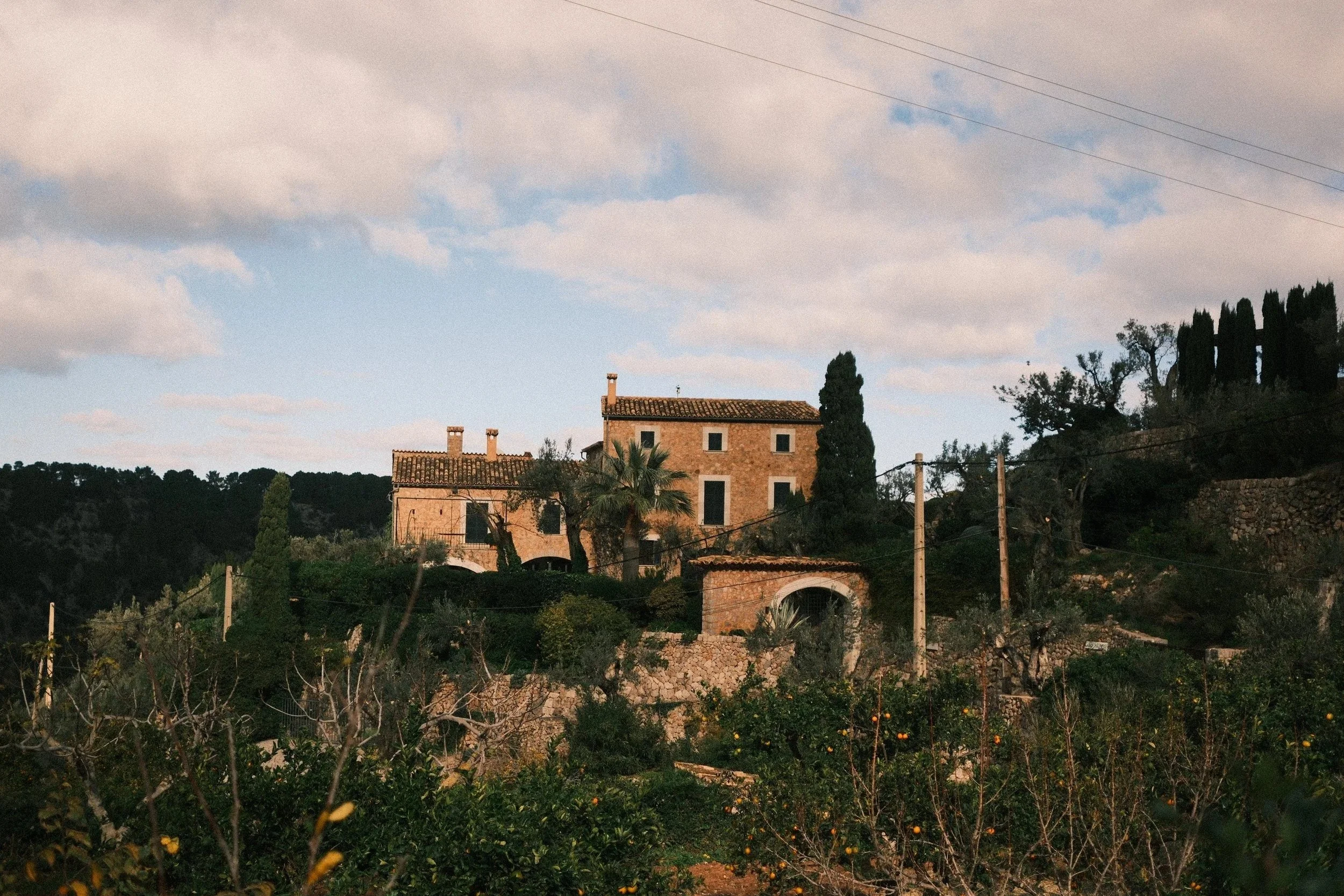 Stone finca among olive terraces under a cloudy sky, Mallorca, Spain - fine art print by Zyan Sachs