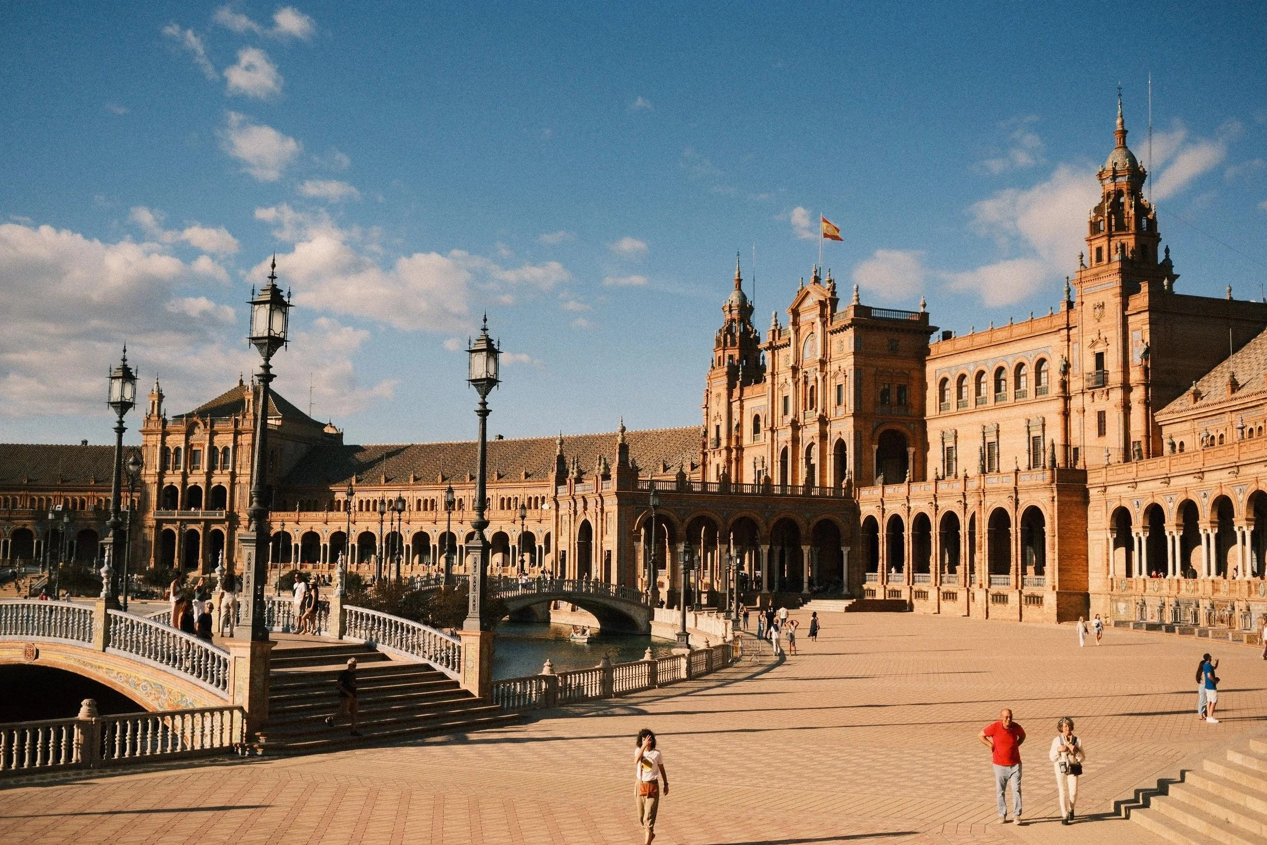 Plaza de España with its curved brick arcade, towers and lampposts, Seville, Spain - fine art print by Zyan Sachs