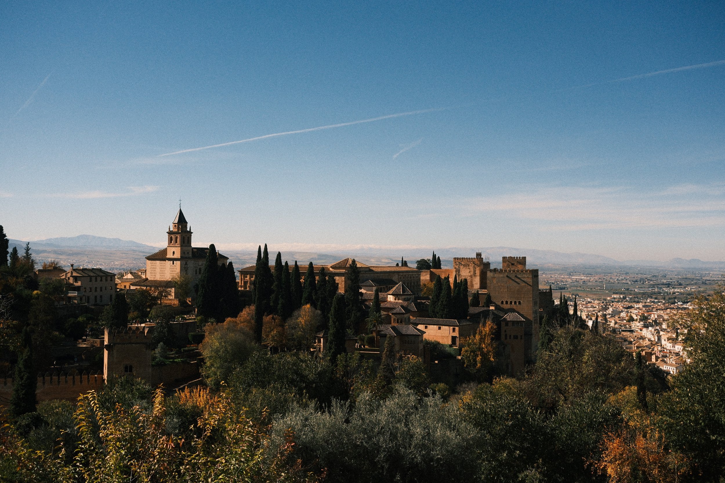 The Alhambra on its wooded hill under a clear sky, Granada, Andalucía, Spain, by Zyan Sachs