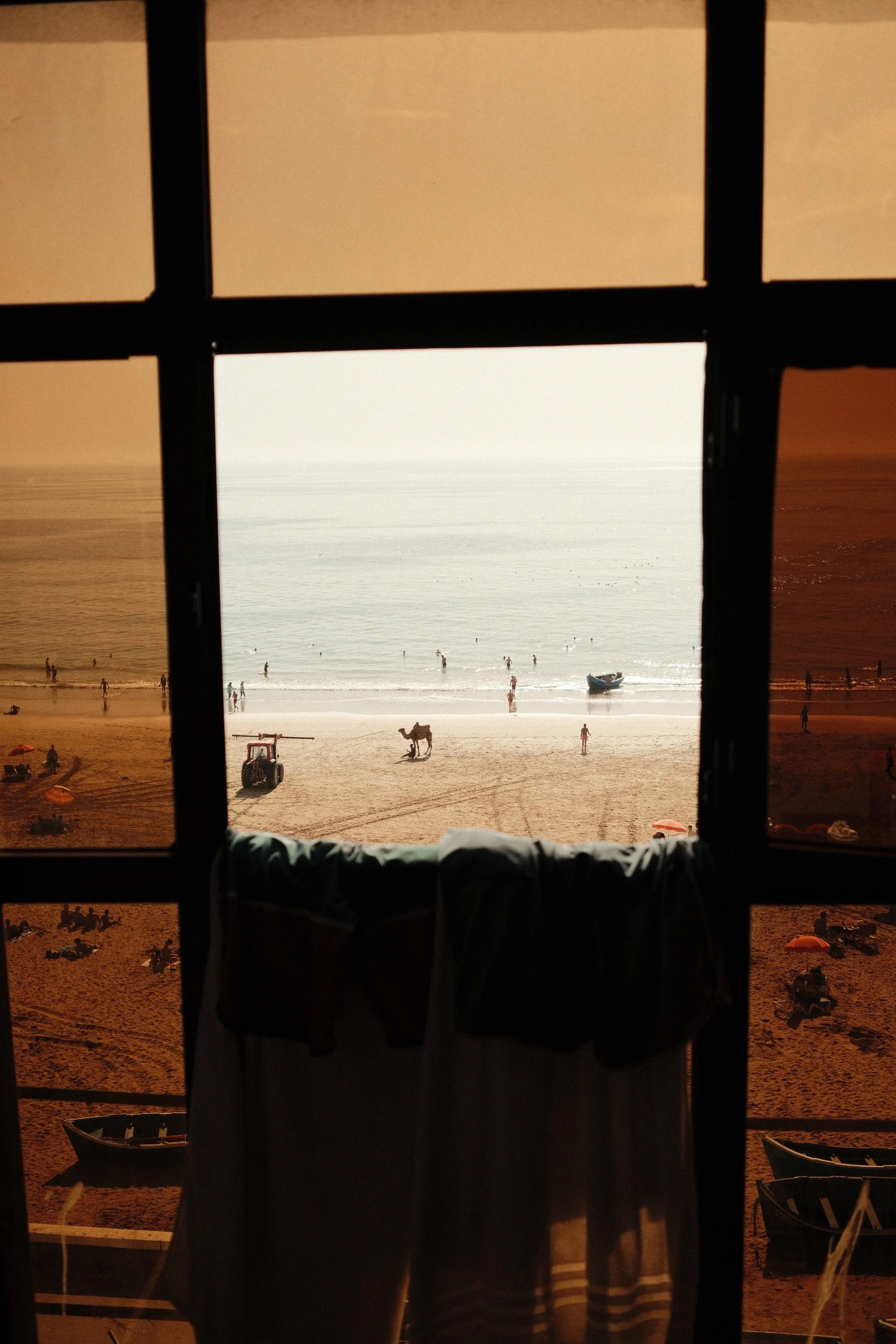 Ocean view through a dark window frame, Taghazout, Morocco - fine art print by Zyan Sachs
