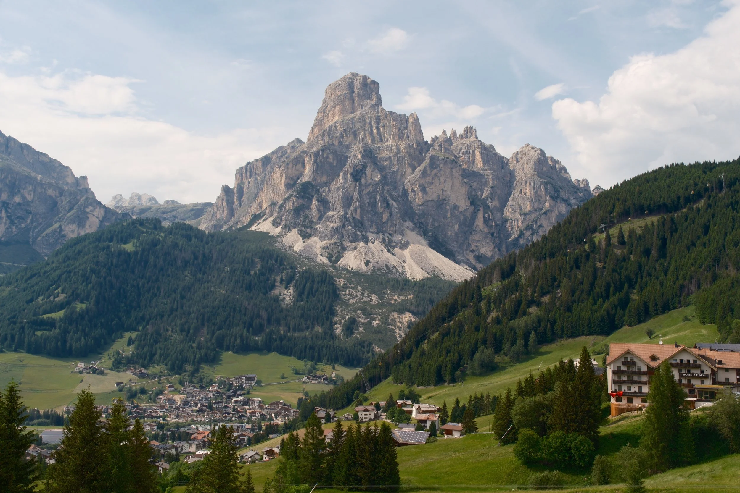 Sassongher peak towering over the village of Corvara and green meadows in Alta Badia, Dolomites, Italy, by Zyan Sachs