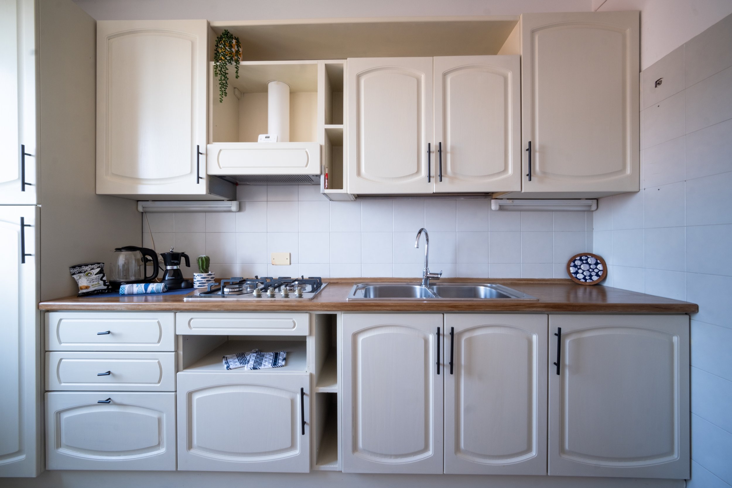 White kitchen with wooden countertops at Casa Stefano, Sardinia, by Zyan Sachs