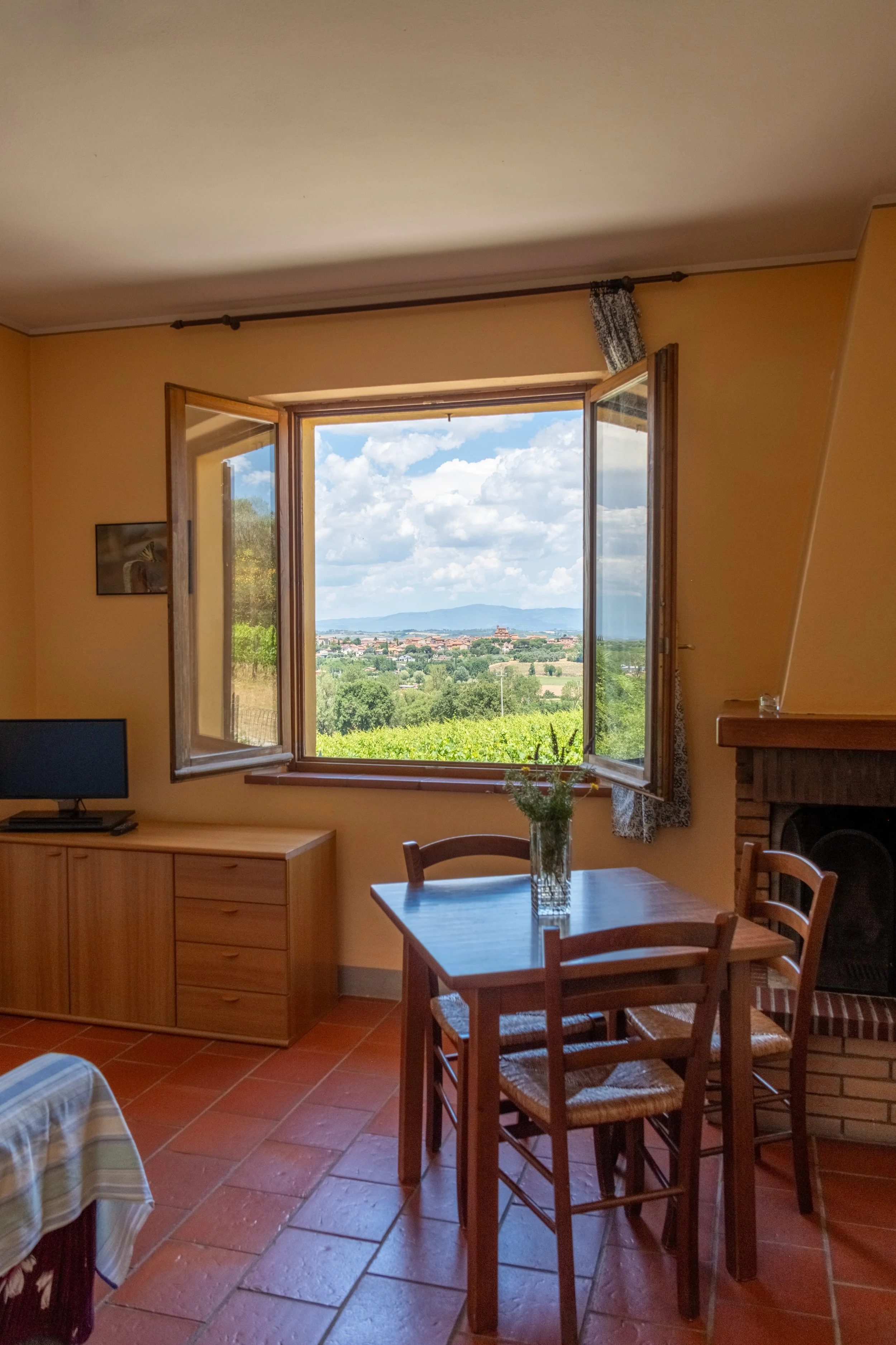 Apartment living and dining room with a window over the countryside at Agriturismo Metina, Montepulciano, Tuscany, by Zyan Sachs