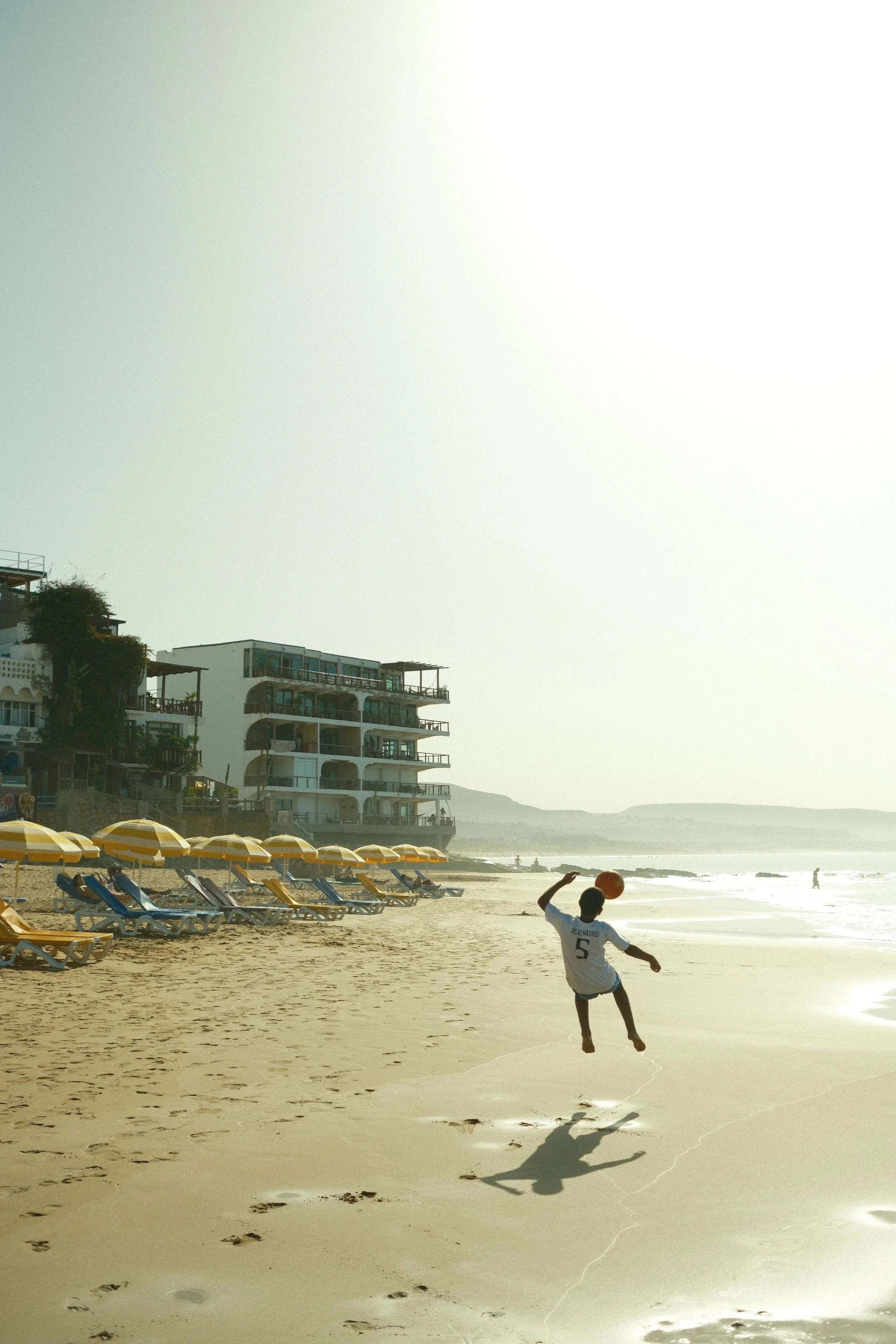 Surfer walking out on the hazy beach in backlight, Taghazout, Morocco - fine art print by Zyan Sachs