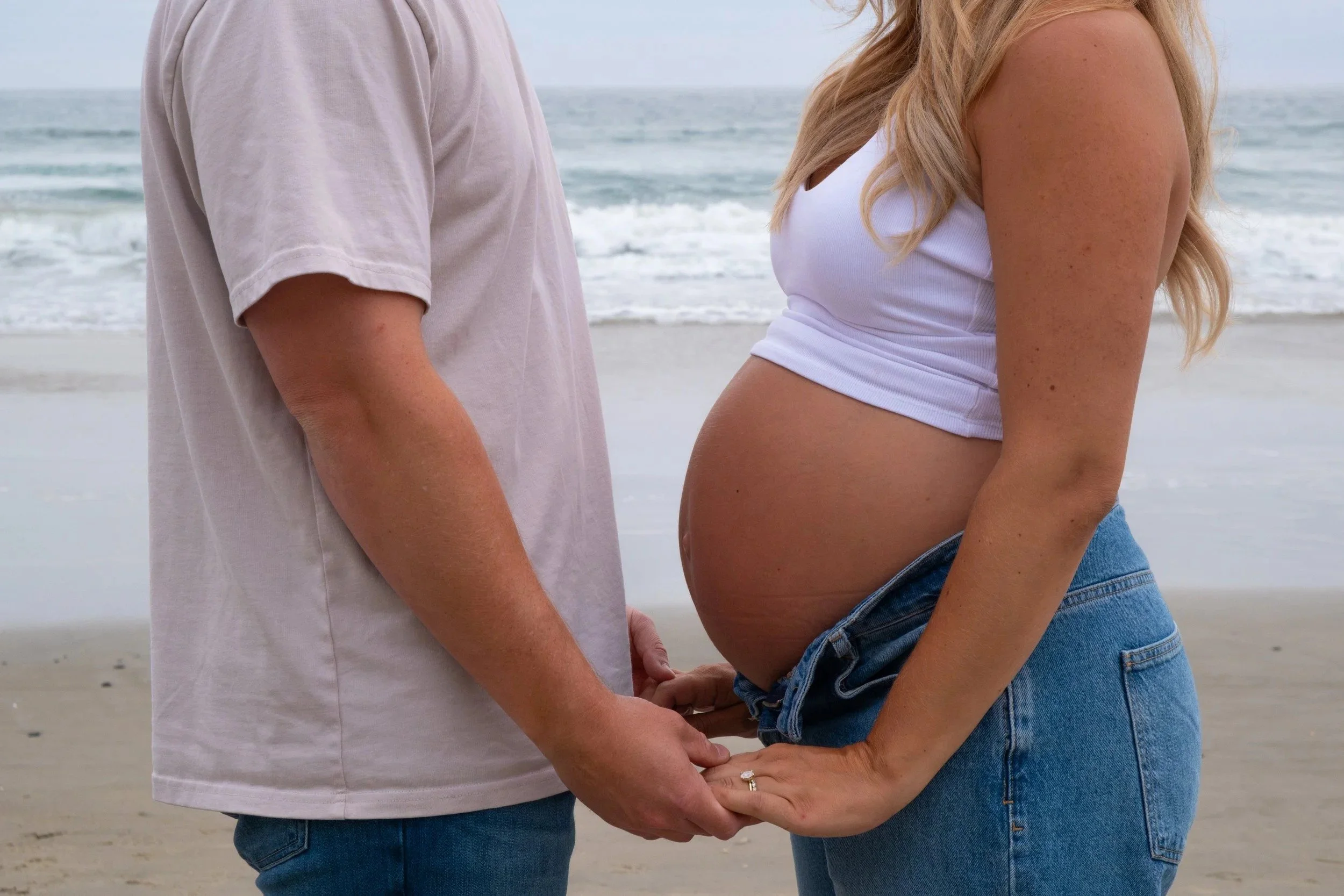 Expecting couple holding hands on the beach, maternity portrait, San Diego, California - portrait photography by Zyan Sachs