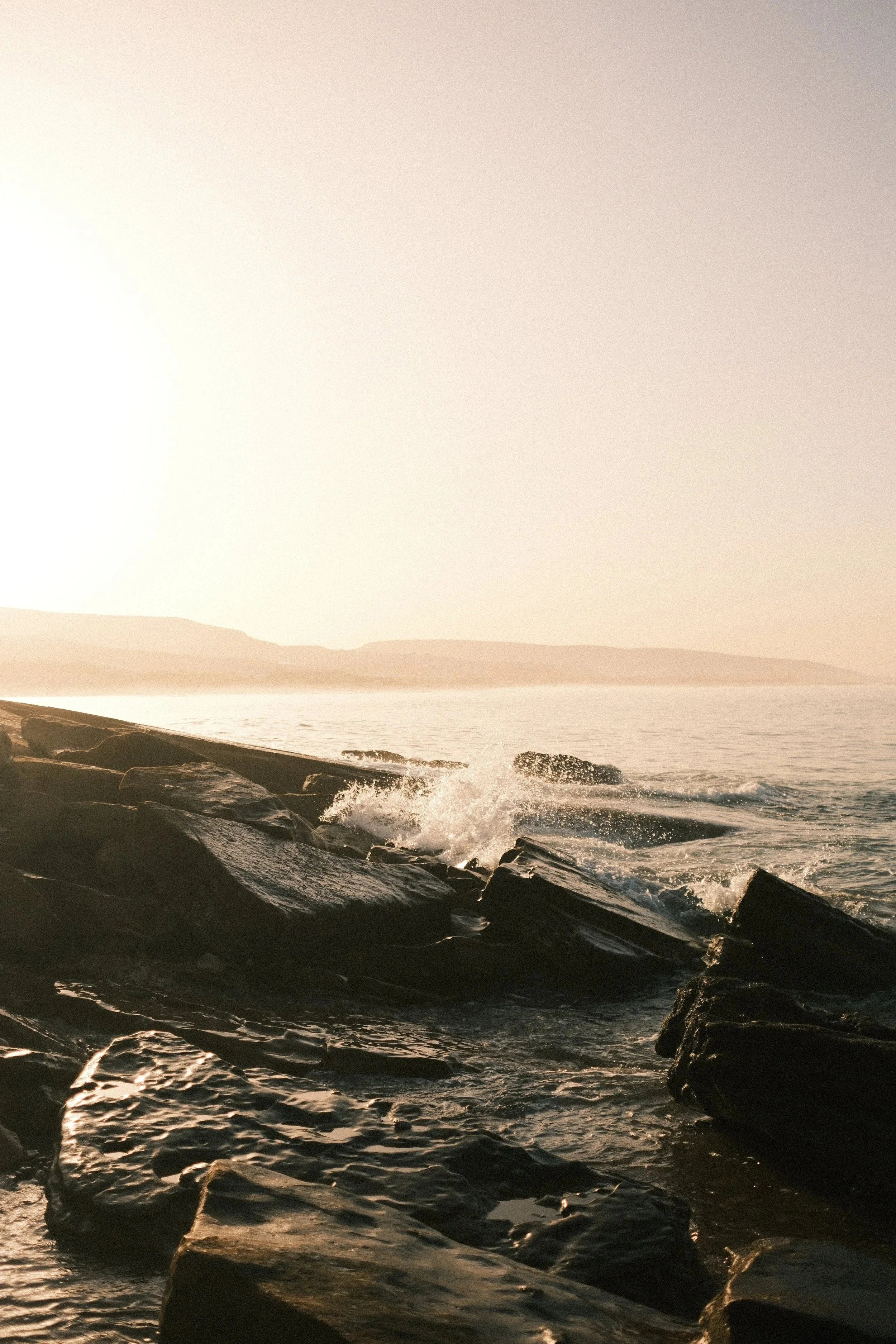 Waves breaking on dark rocks at golden hour, Taghazout, Morocco - fine art print by Zyan Sachs