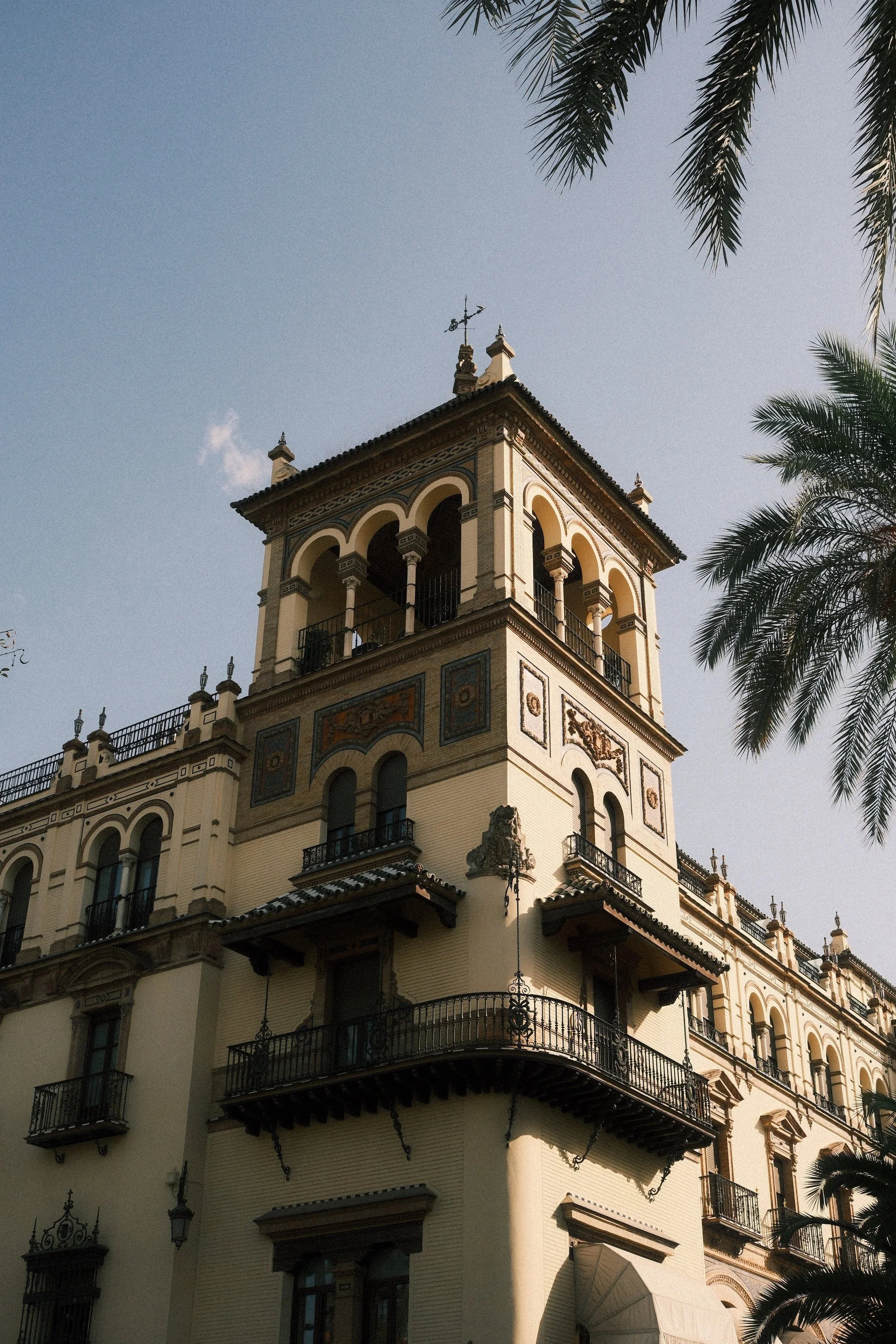 Tower of the Hotel Alfonso XIII framed by palm fronds, Sevilla, Spain, by Zyan Sachs