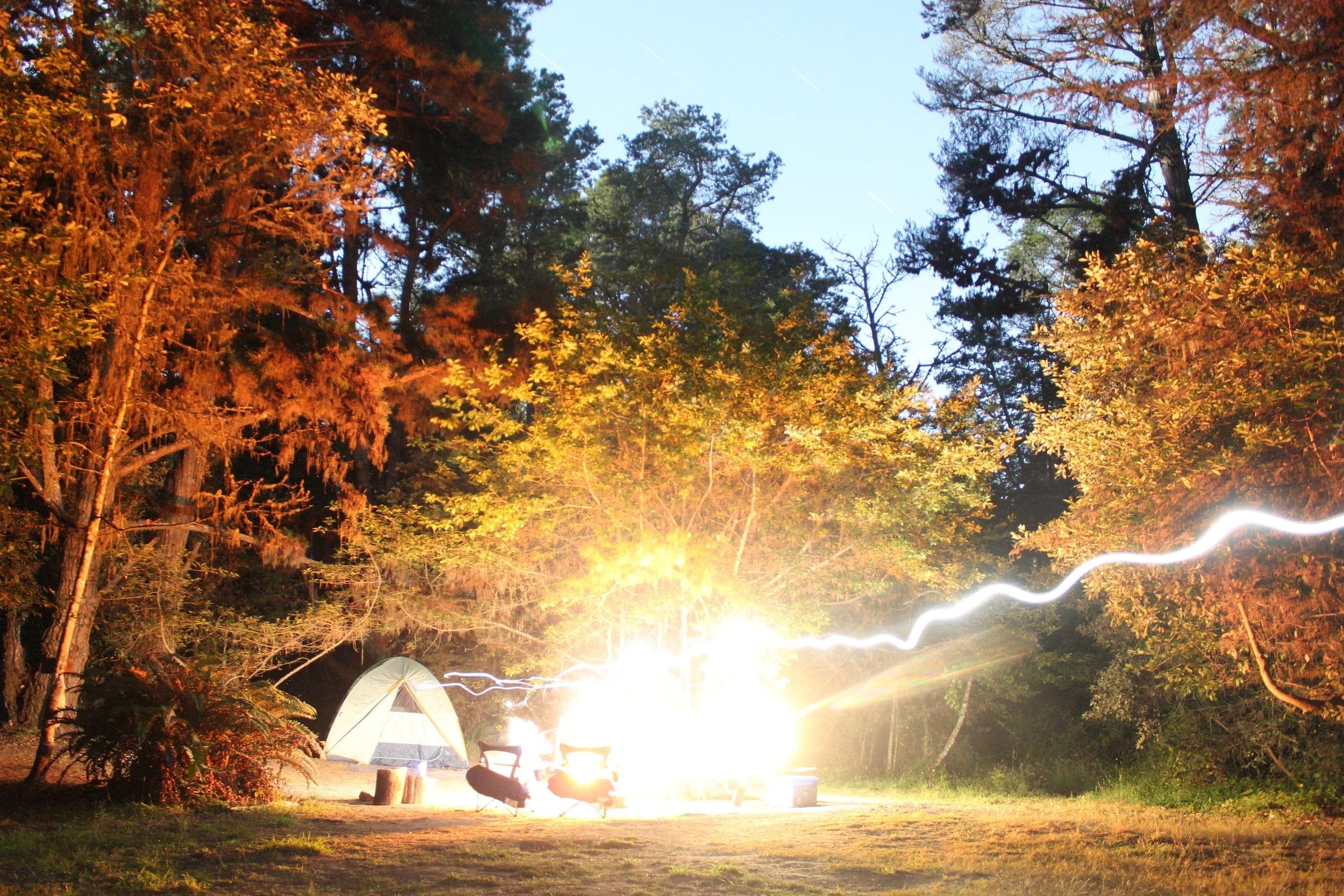 Glowing tent at a campsite among autumn trees at dusk, California - travel photography and fine art prints by Zyan Sachs