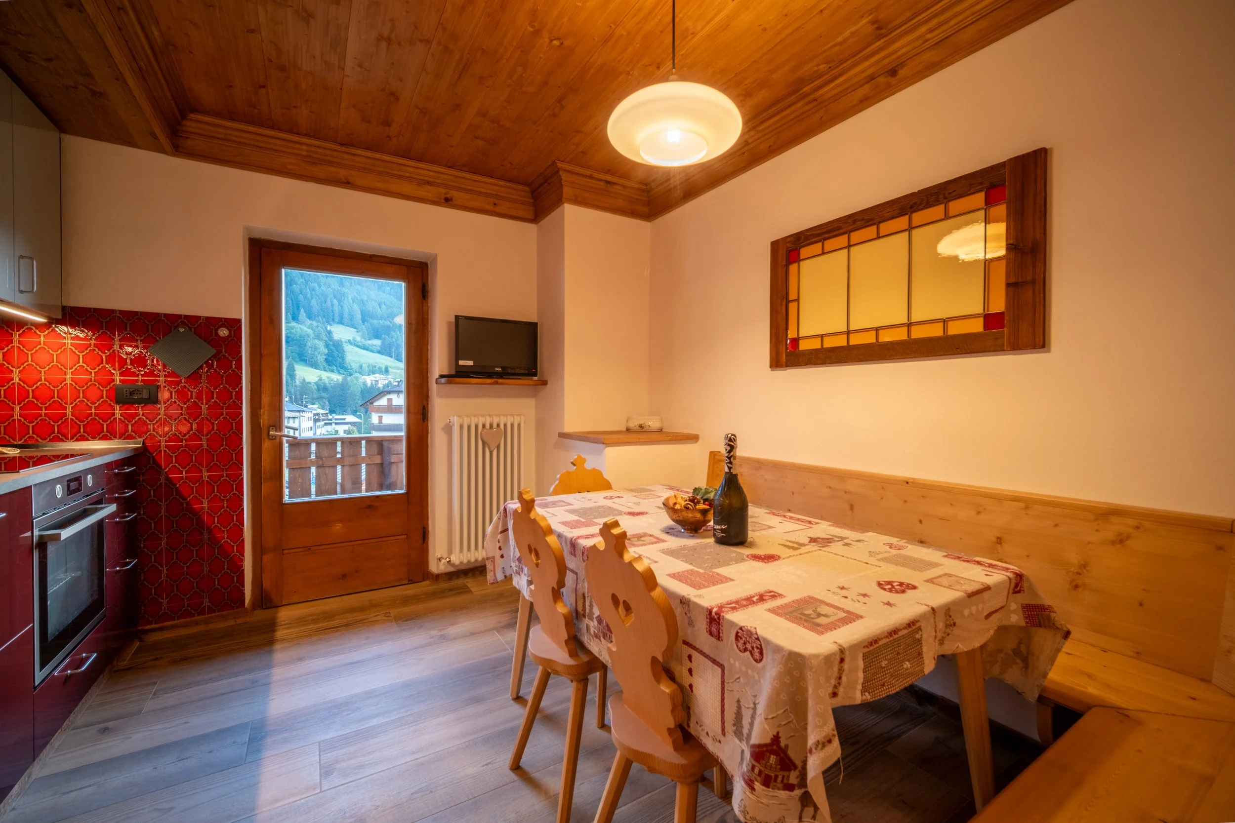 Alpine kitchen and dining table under a warm wood ceiling at Al Borgo da Agata, Dolomites, by Zyan Sachs