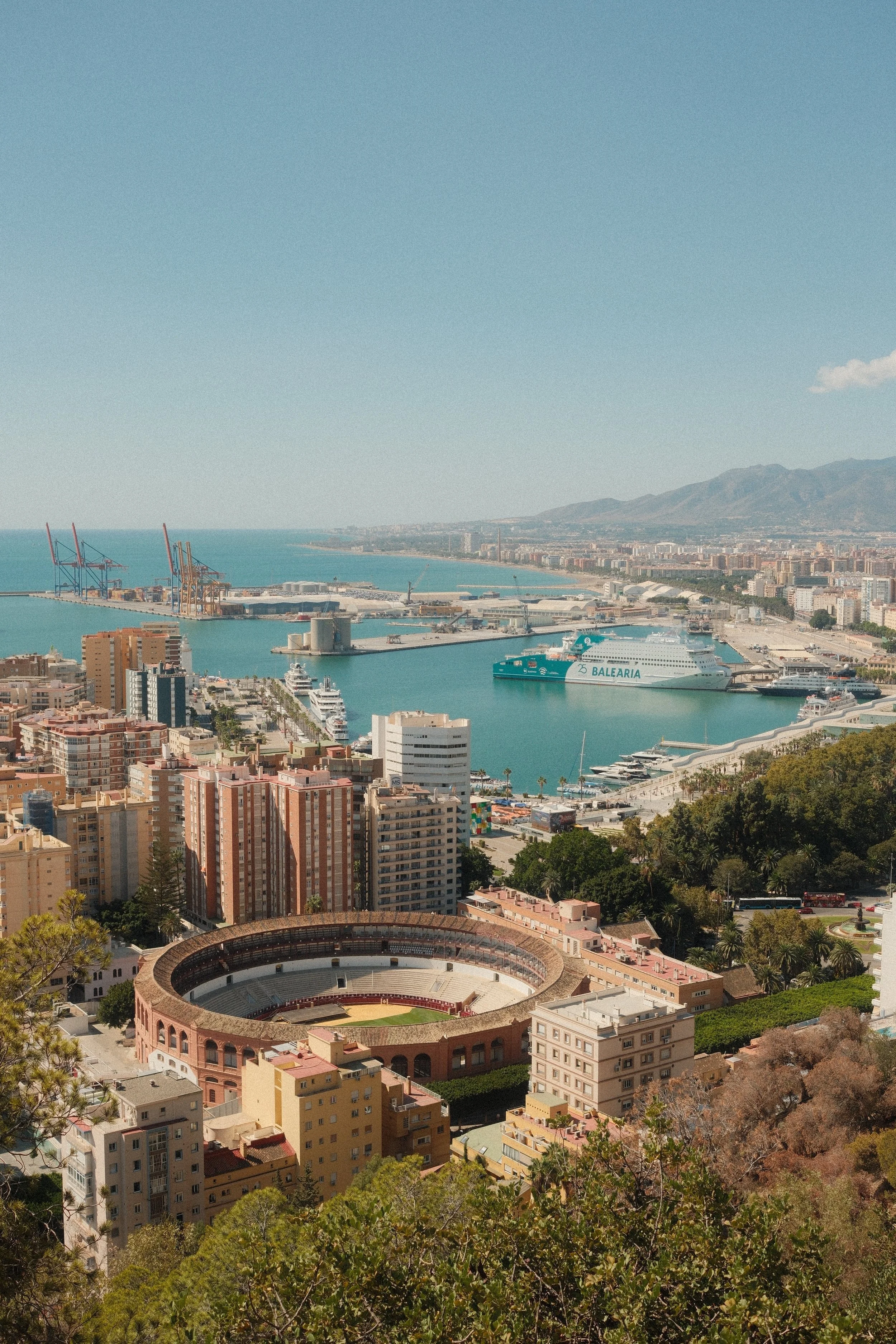 View over Málaga with its bullring, port and Mediterranean coastline, Málaga, Spain - fine art print by Zyan Sachs
