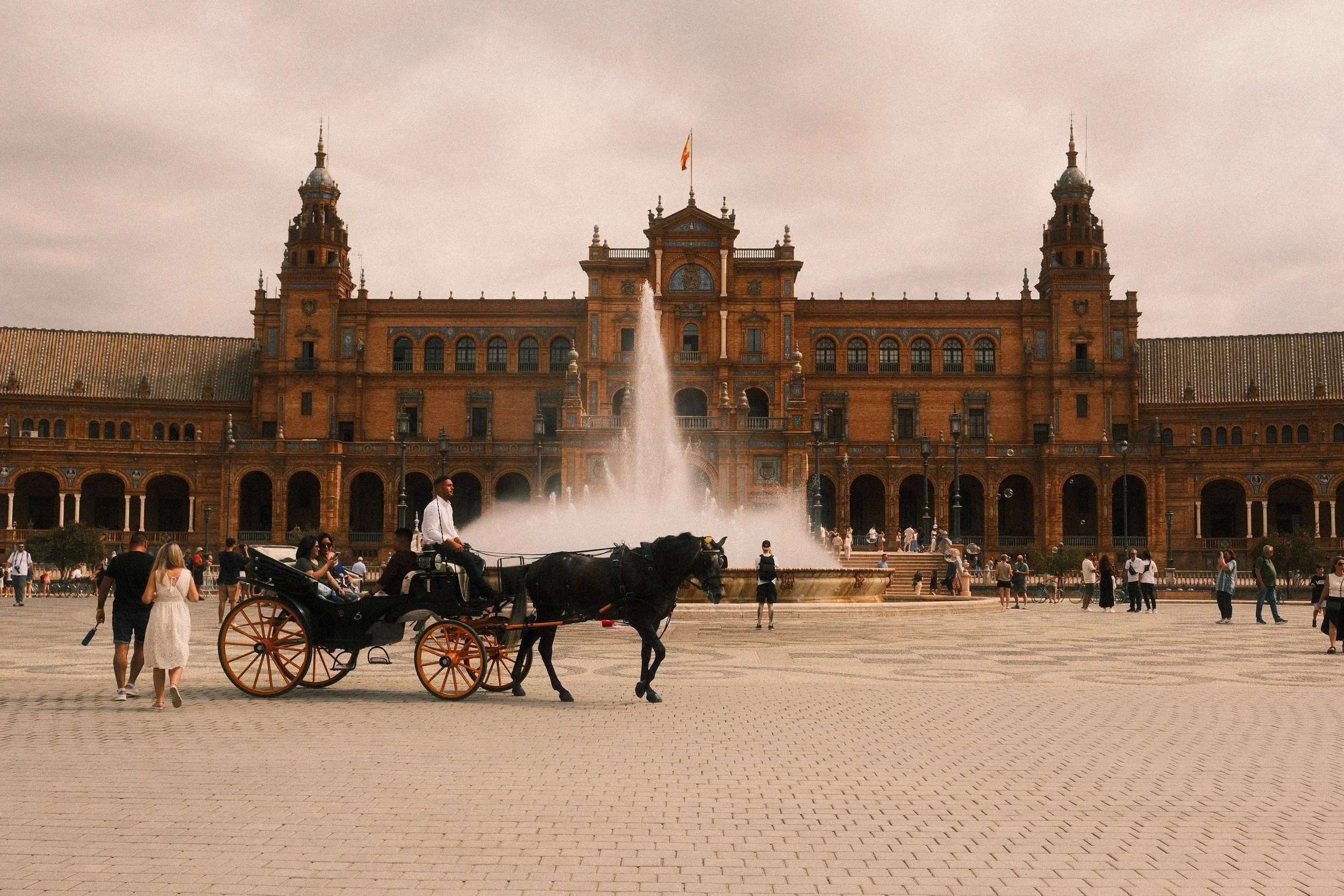 Horse-drawn carriage and fountain in front of the Plaza de España, Seville, Spain - fine art print by Zyan Sachs
