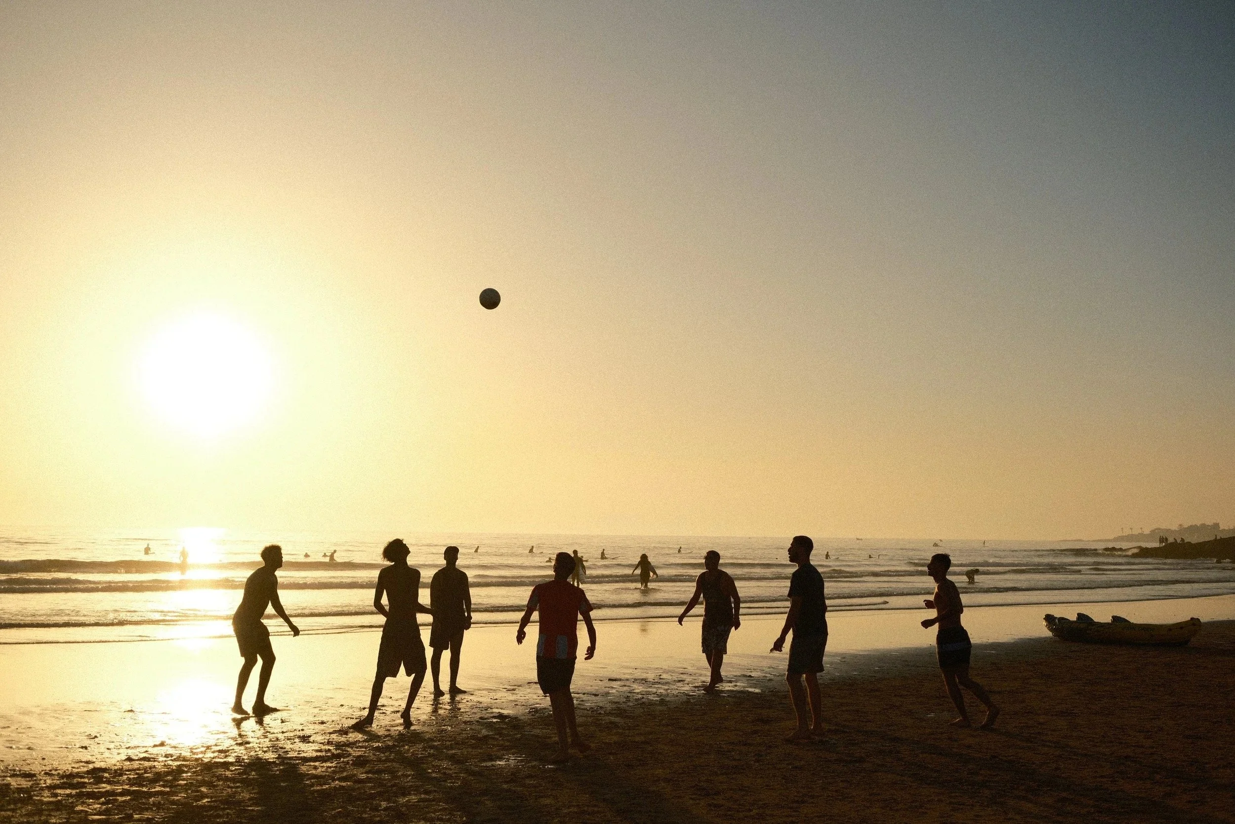 Silhouettes of people playing beach volleyball in front of the setting sun, Taghazout, Morocco - fine art print by Zyan Sachs