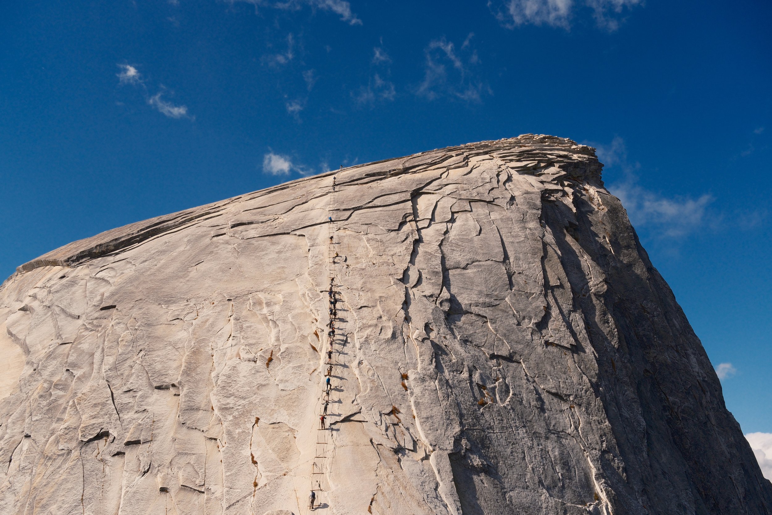 Hikers on the Half Dome cable route up the granite summit dome, Yosemite National Park, California, by Zyan Sachs