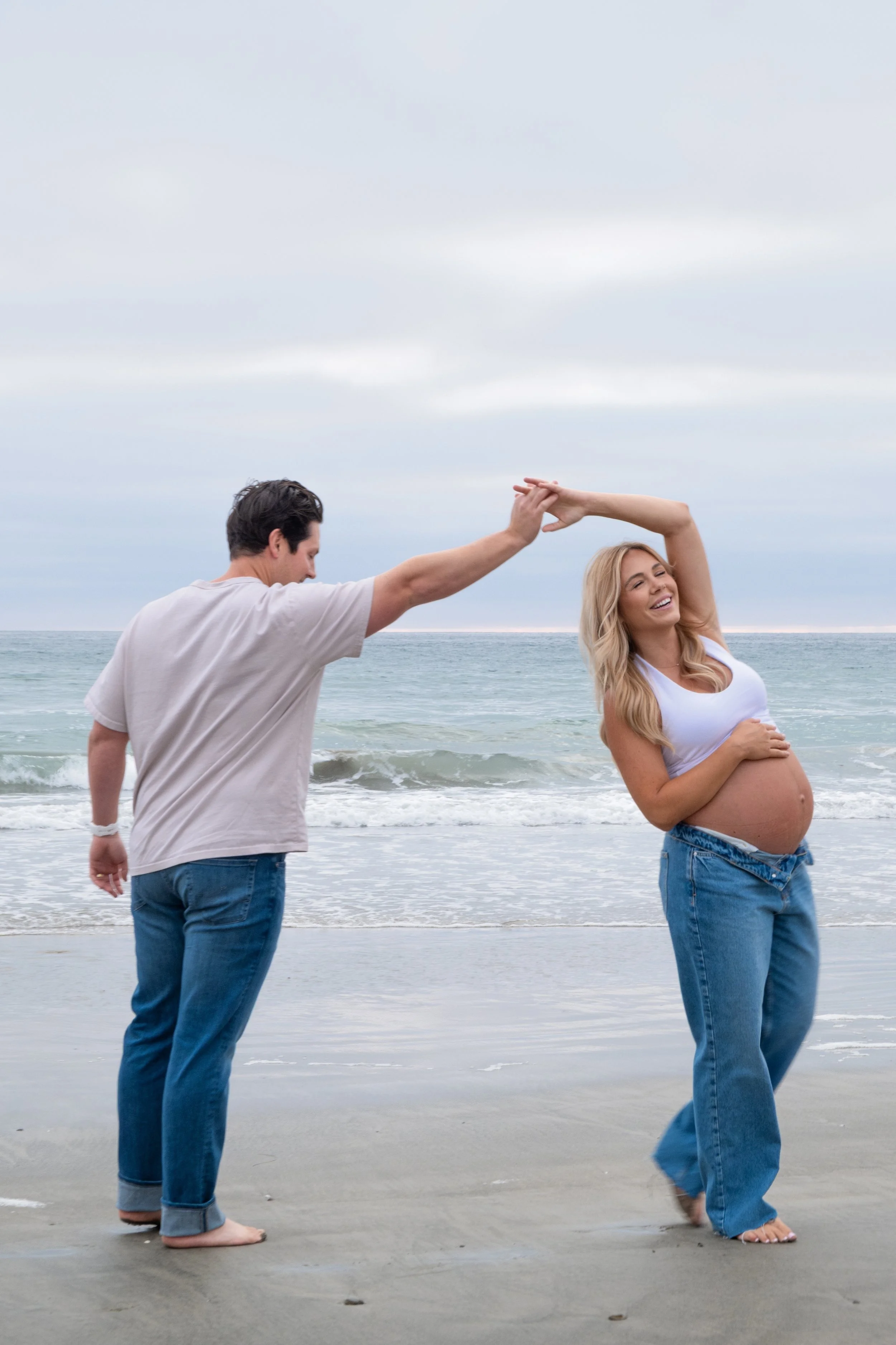 Couple dancing barefoot on the beach during a maternity shoot, San Diego, California - portrait photography by Zyan Sachs