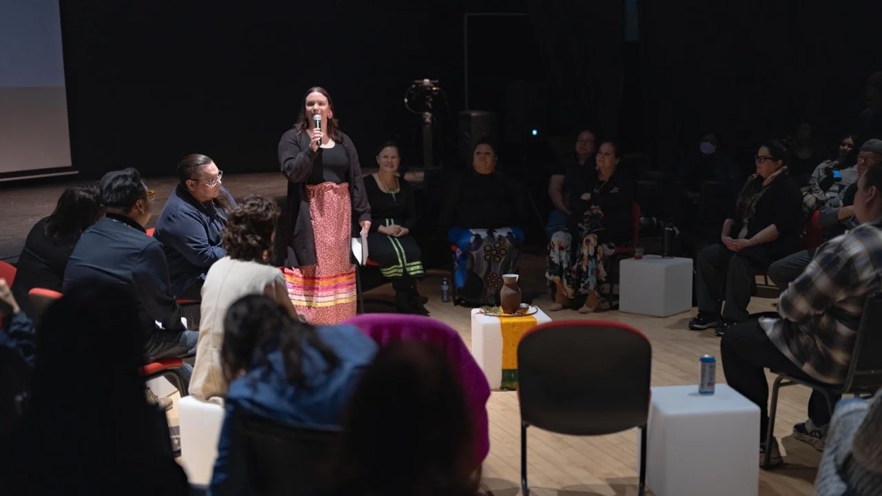 Wide angle of a person presenting front of an audience.