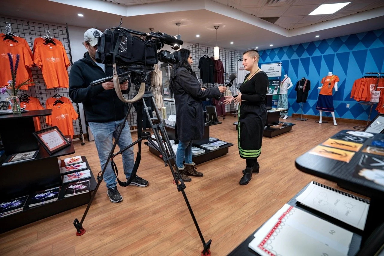 Wide angle of a person standing front of a news camera.