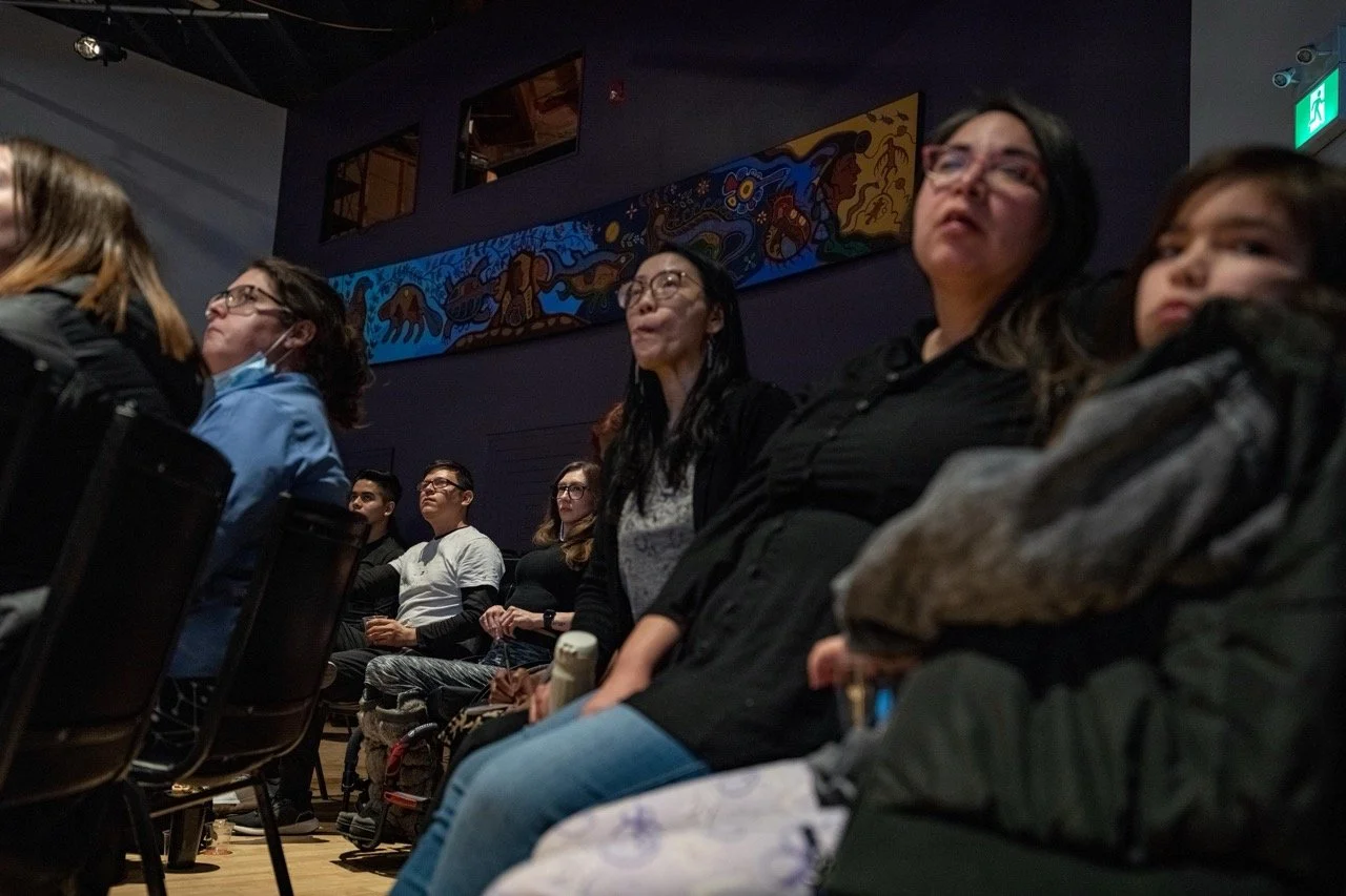 Close up of audiences sitting and watching a performance.
