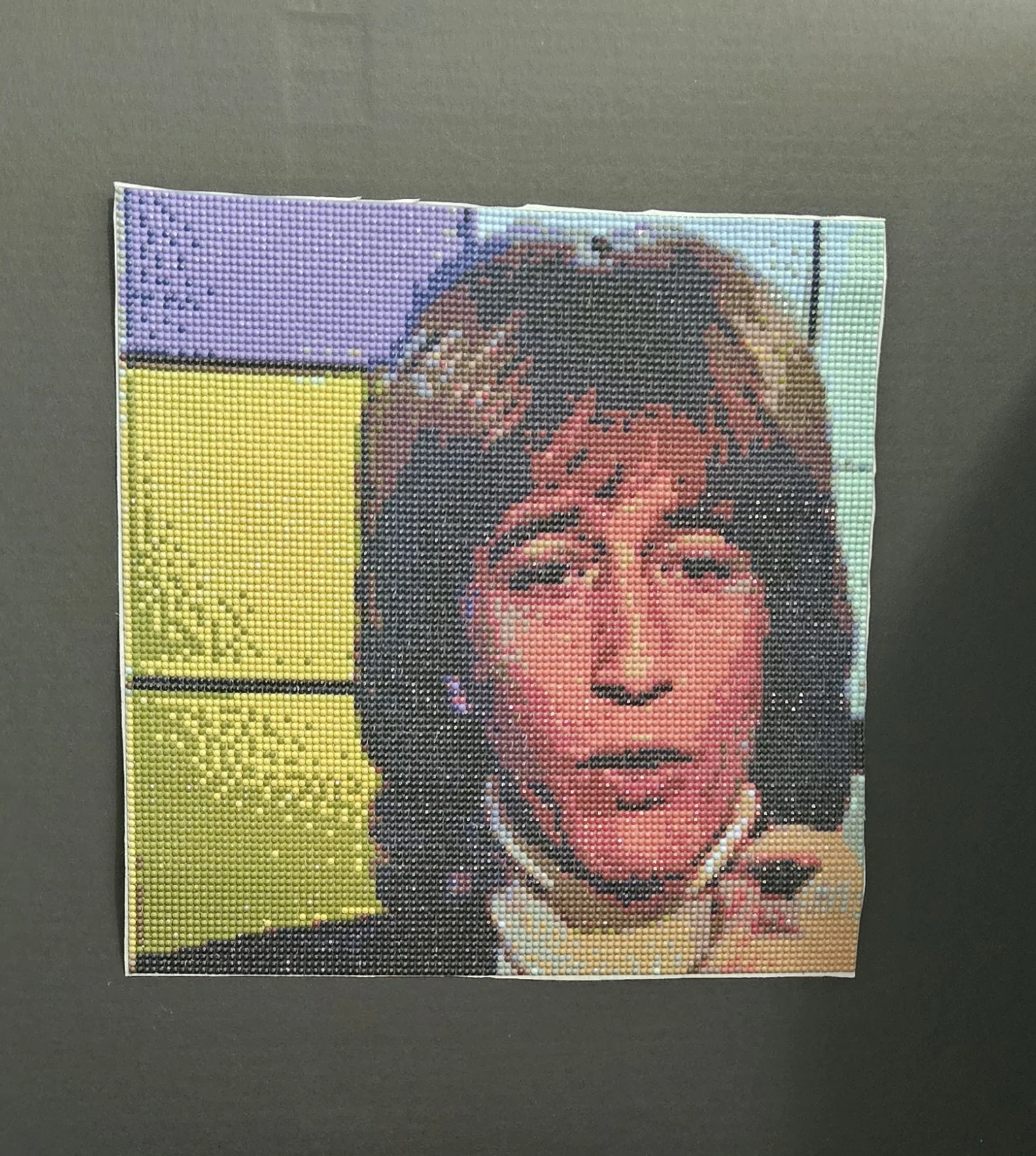 Pixel art portrait of Robin Gibb with long hair and a turtleneck, set against a colorful background.