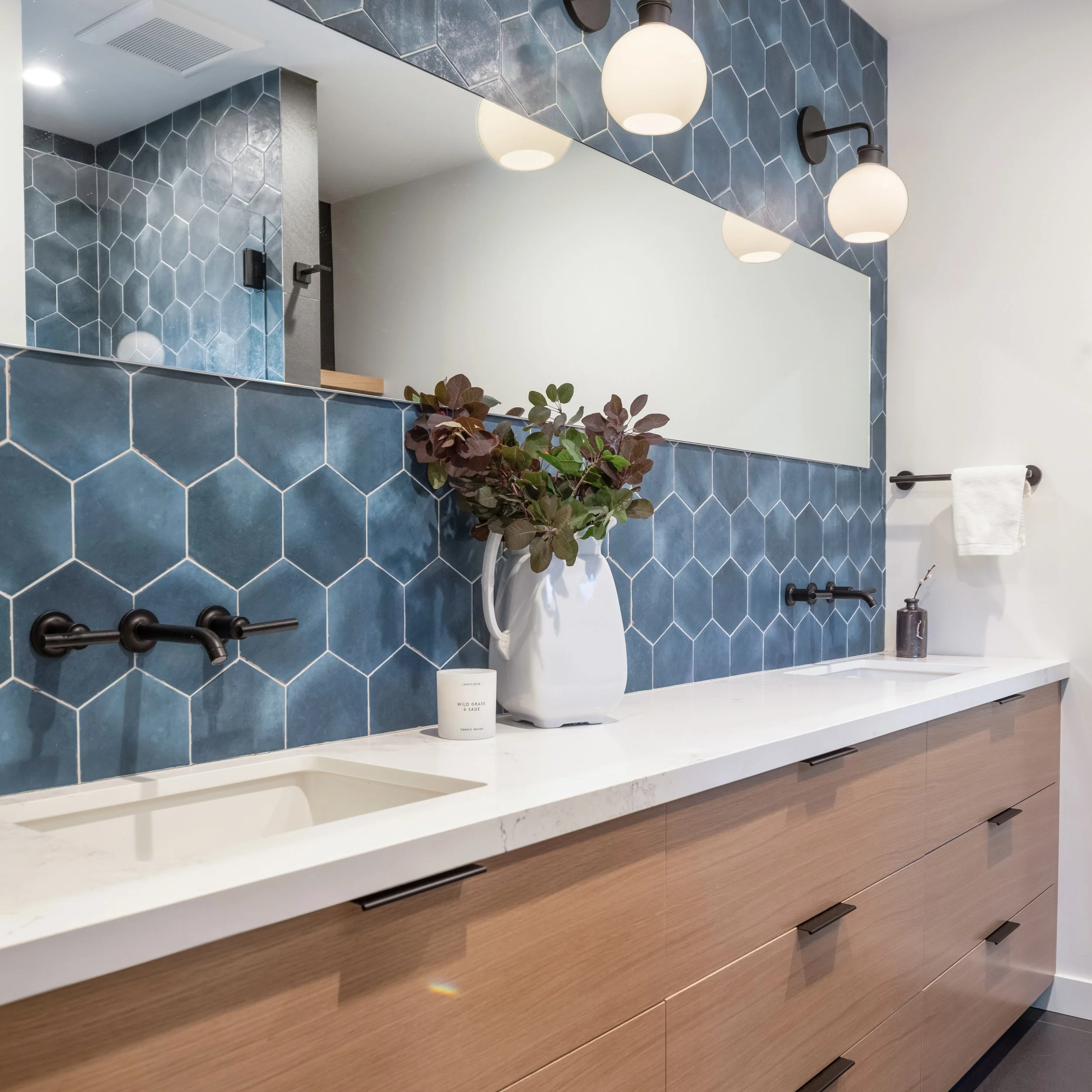 Custom bathroom remodel in Santa Cruz County featuring blue hexagon tile backsplash, walnut floating vanity, and matte black fixtures