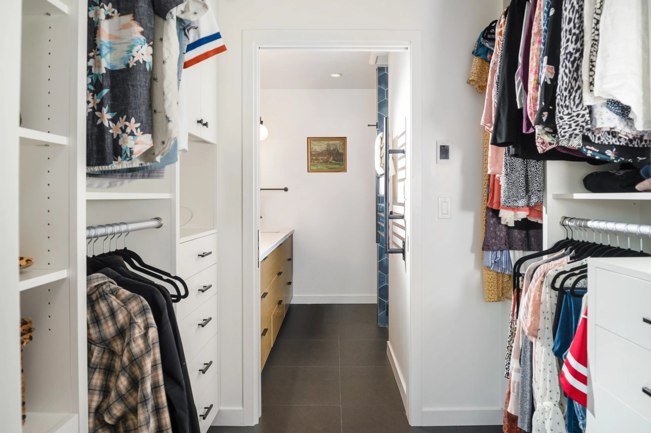 Custom walk-in closet system with built-in drawers, shelving, and hanging storage designed for a Santa Cruz County home by The Closet & Bath Company.