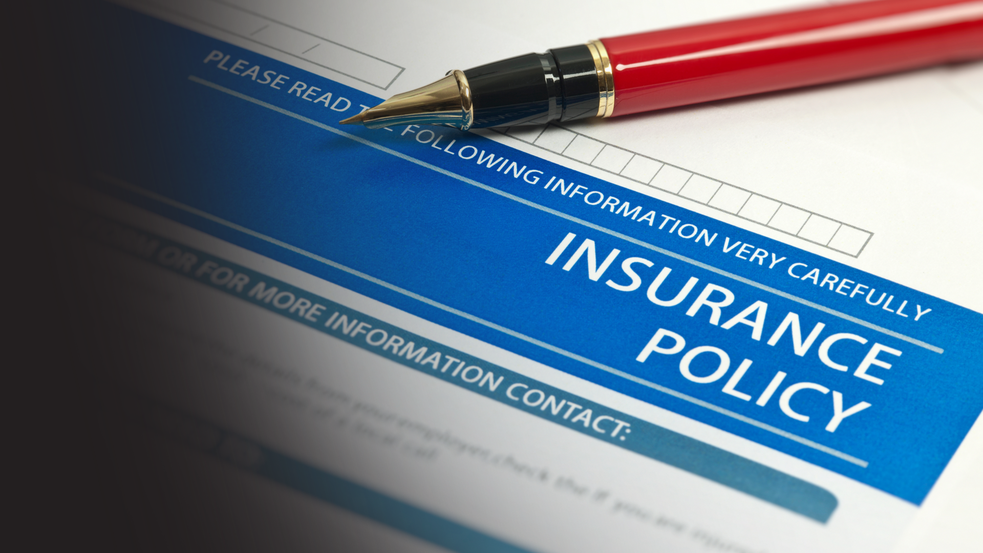 Insurance policy form with a red pen on top.