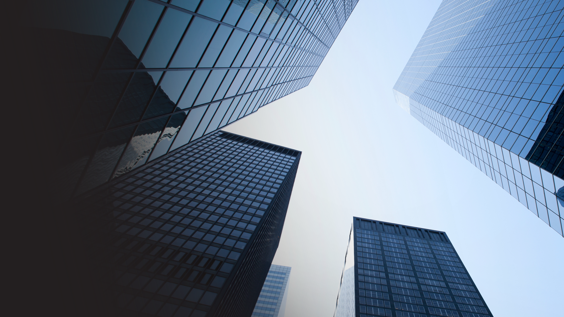 Looking up at tall glass skyscrapers in an urban cityscape.
