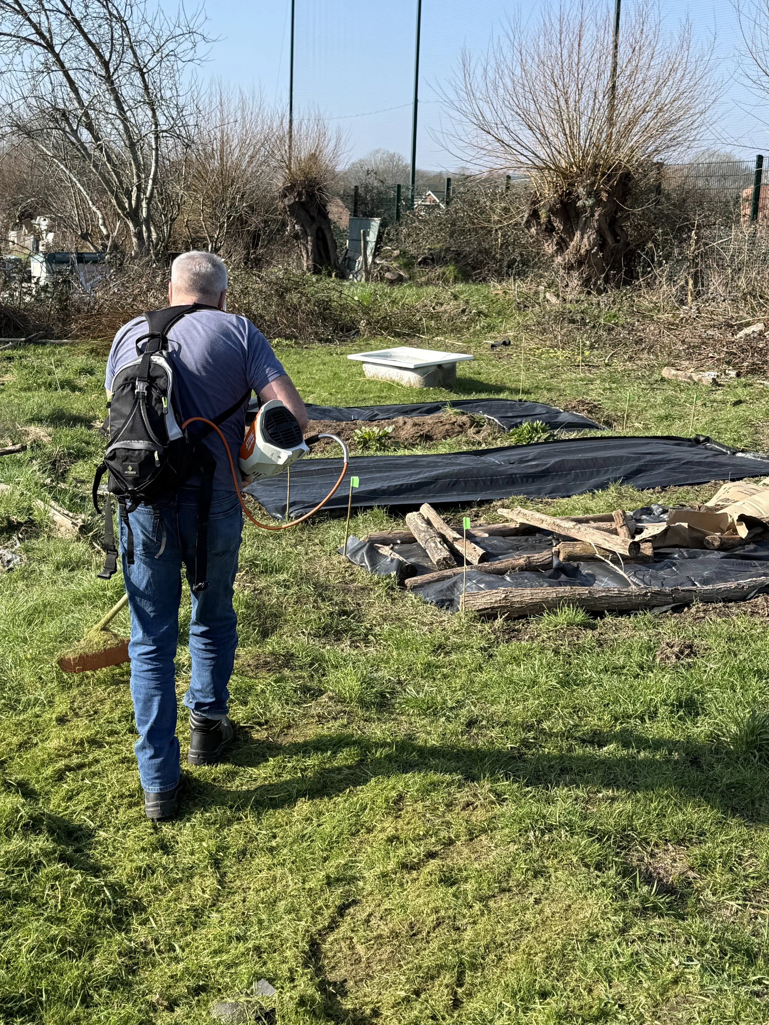 Vollenteer cutting back the grass as its starting to grow