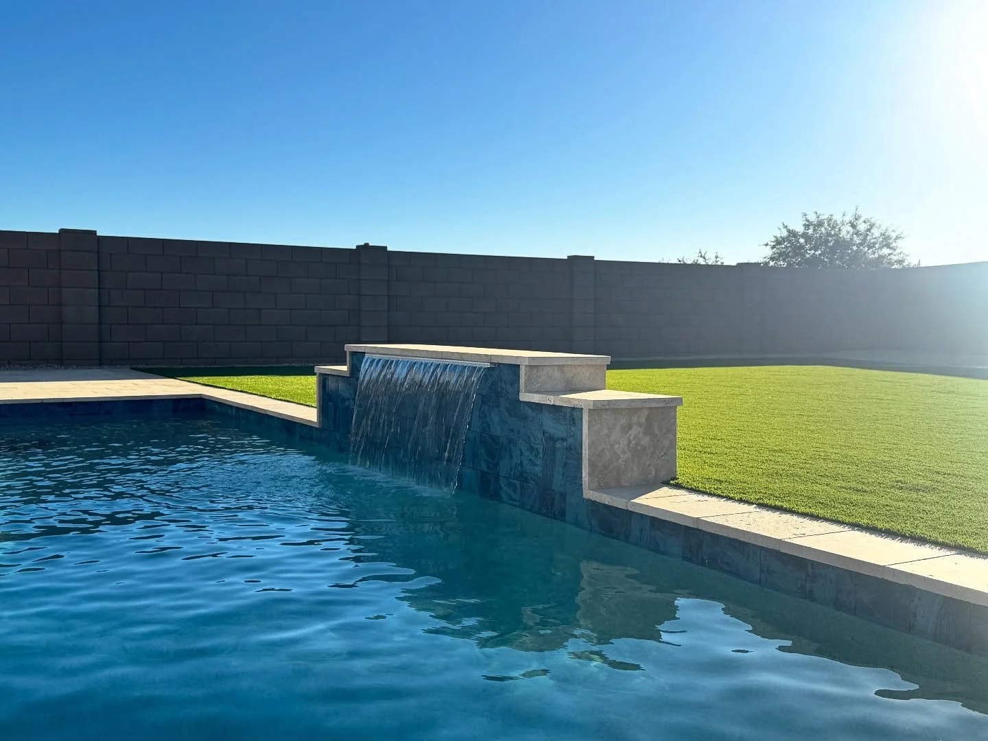 This is one way to elevate your backyard 💦
A travertine-wrapped water feature with bold tile contrast makes this design pop&mdash;bringing texture and clean lines together for a perfectly fitted look. A balance of style and flow that ties into the w