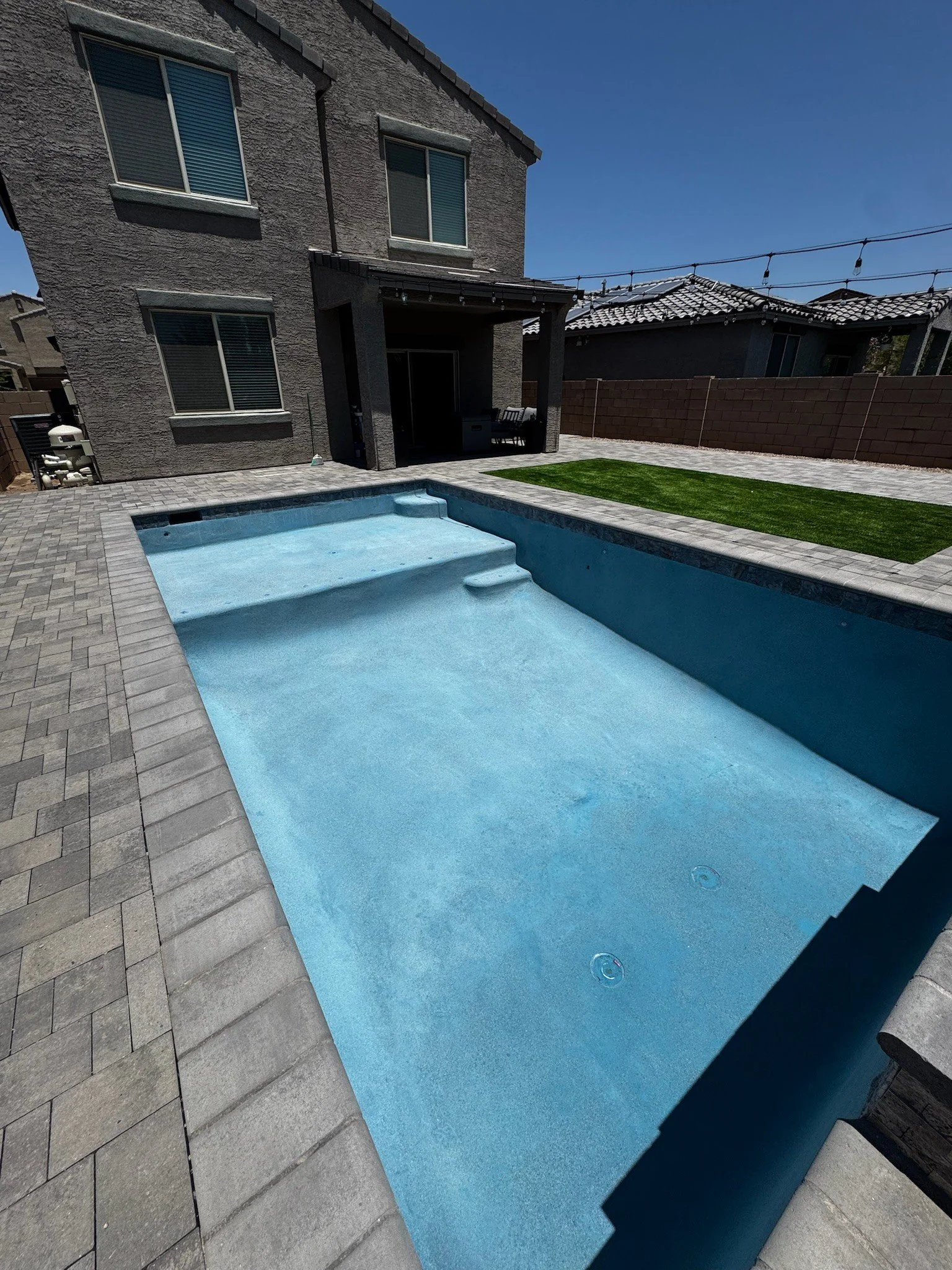Custom rectangular pool with a tanning ledge and light plaster finish by Meraki Pools AZ in Tucson, Arizona.