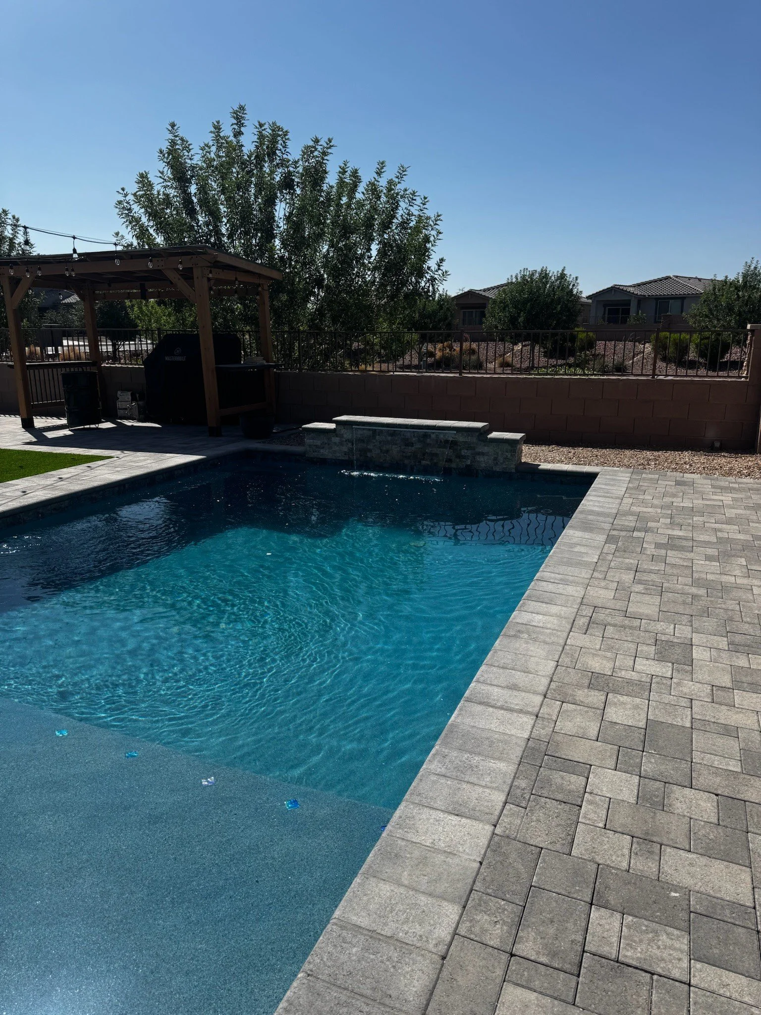 Geometric custom swimming pool with clean lines and a travertine surround by Meraki Pools AZ in Tucson, Arizona.