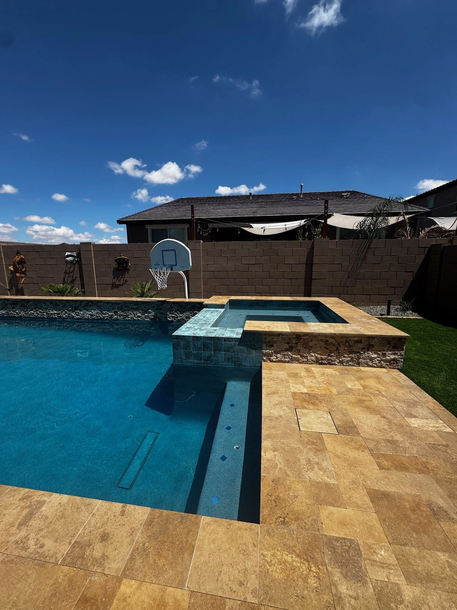 Backyard pool and raised spa with spillways and outdoor living by Meraki Pools AZ in Tucson, Arizona.
