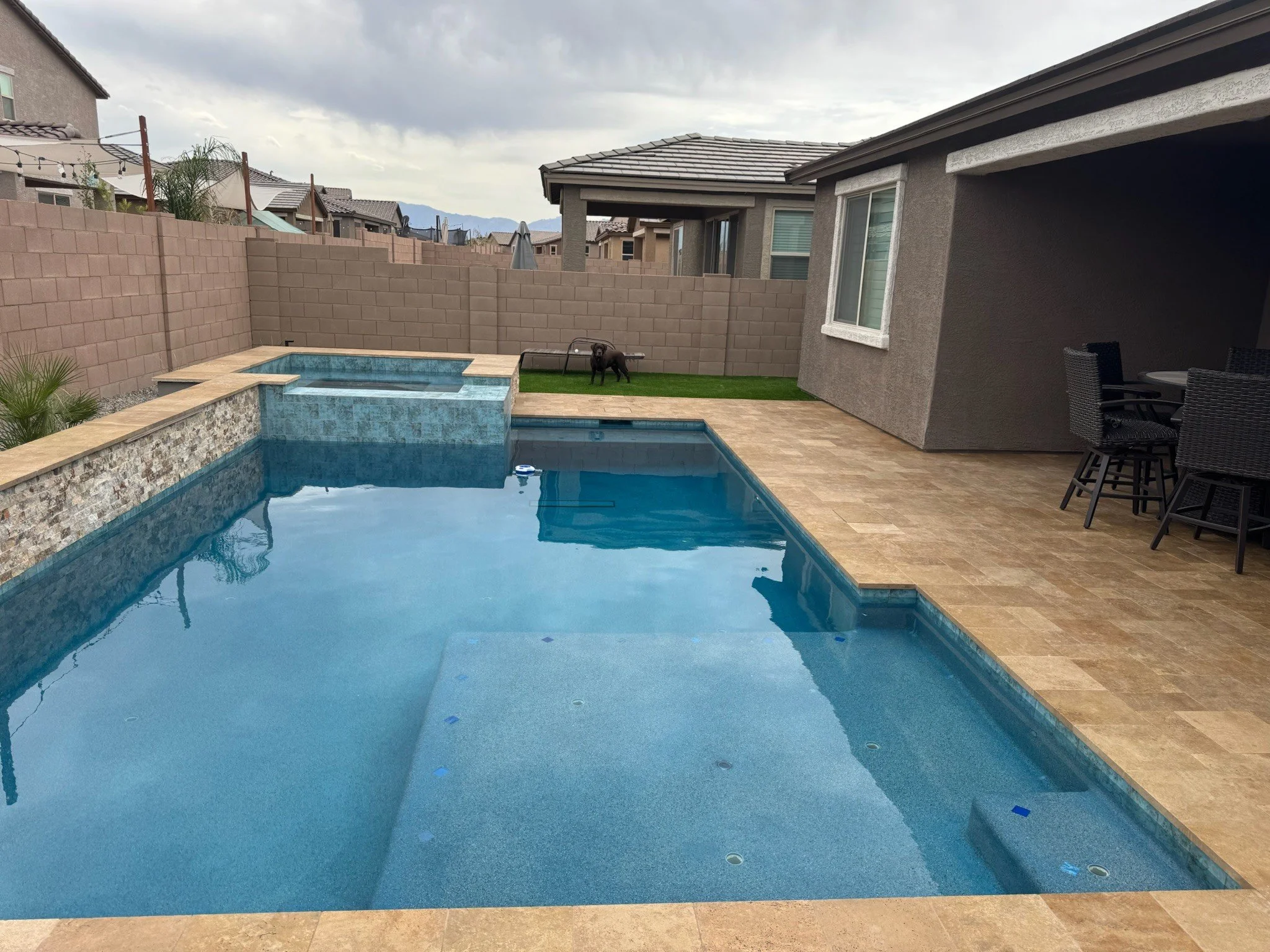 Geometric custom pool with a tanning ledge and paver decking by Meraki Pools AZ in Tucson, Arizona.