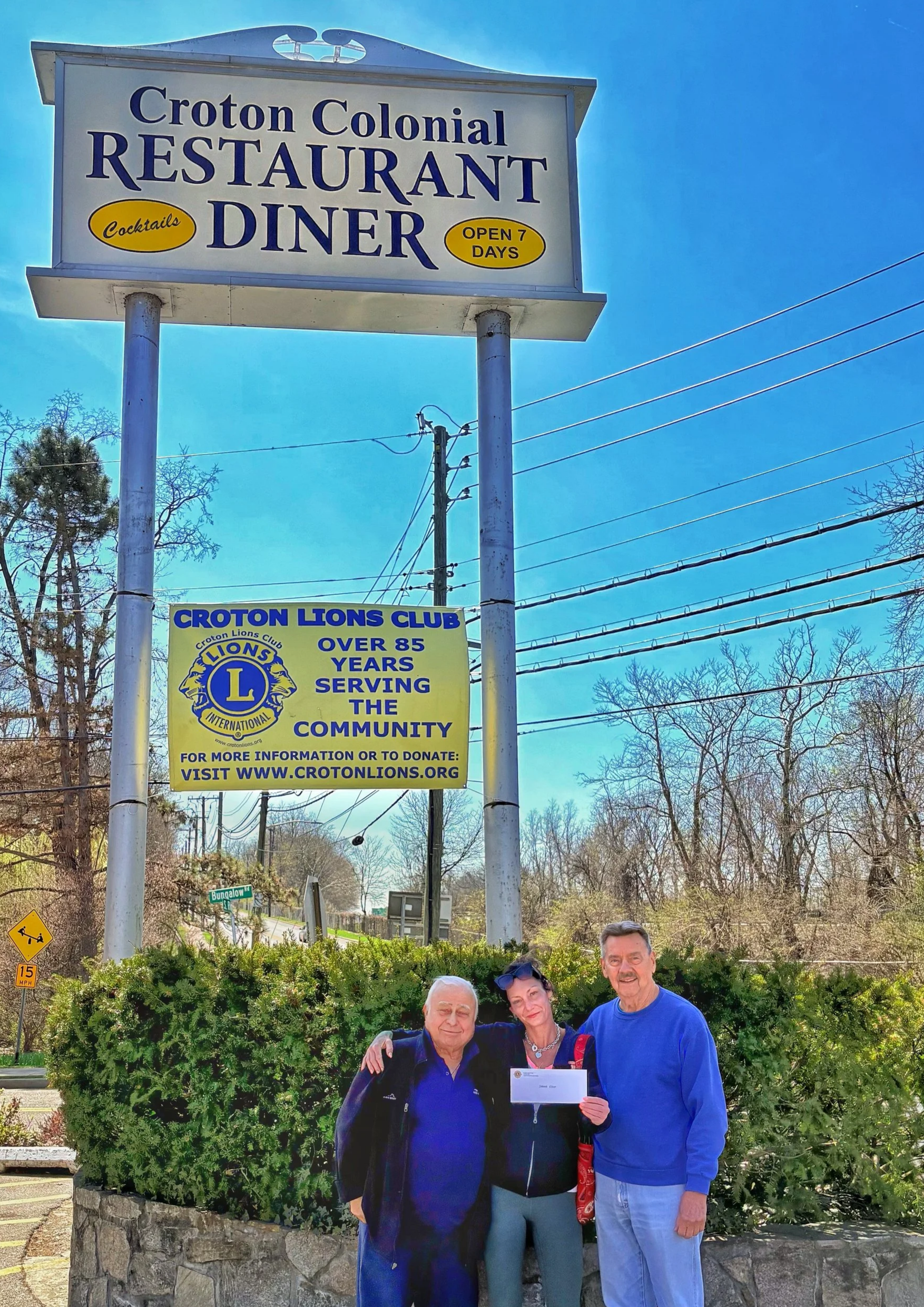Pete Tsagarakis and Bob Anderson of Croton Lions Club present a check to Croton resident Shanna Elliot, who lost all her possessions in a fire.two weeks earlier.