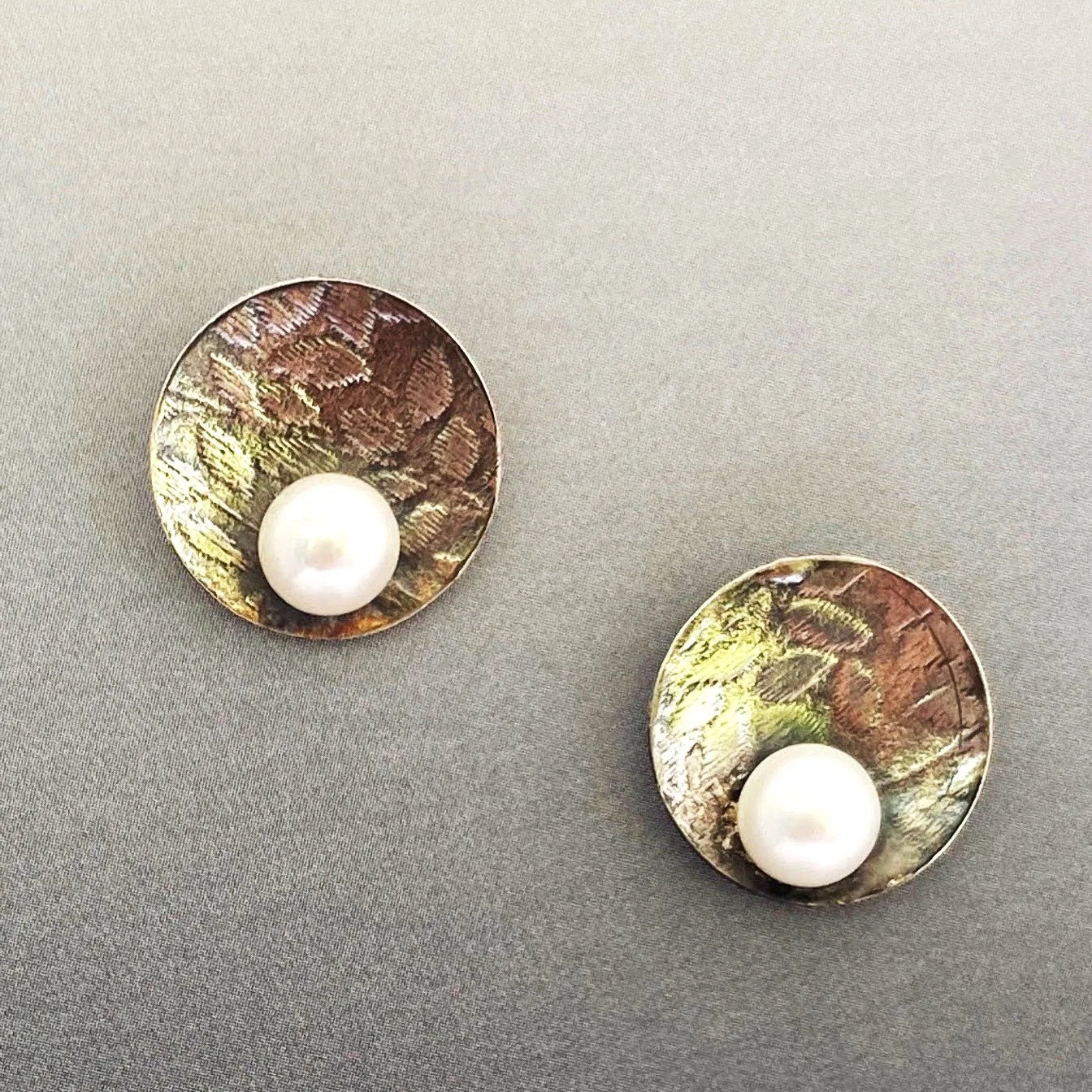 Nancy Ennis has created these two stunning designs, available at Artists' Undertaking Gallery in Occoquan, VA. 

Sterling silver post earrings feature a delicate floral texture that is highlighted by a subtle patina which enhances the lustrous white 