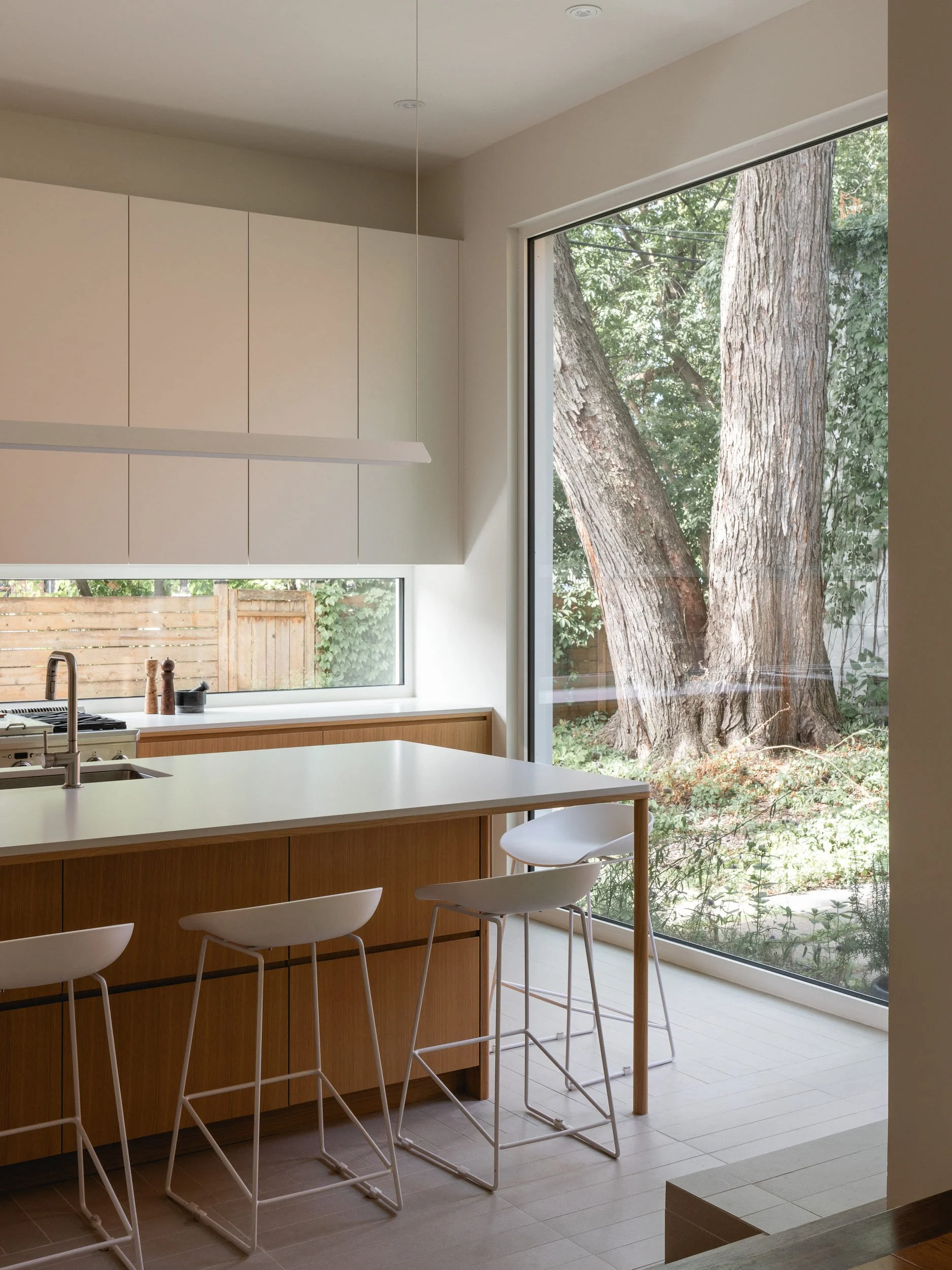 Cartier-ilot-cuisine-tabourets-fenetre-arbre-Cassia-Construction.jpg