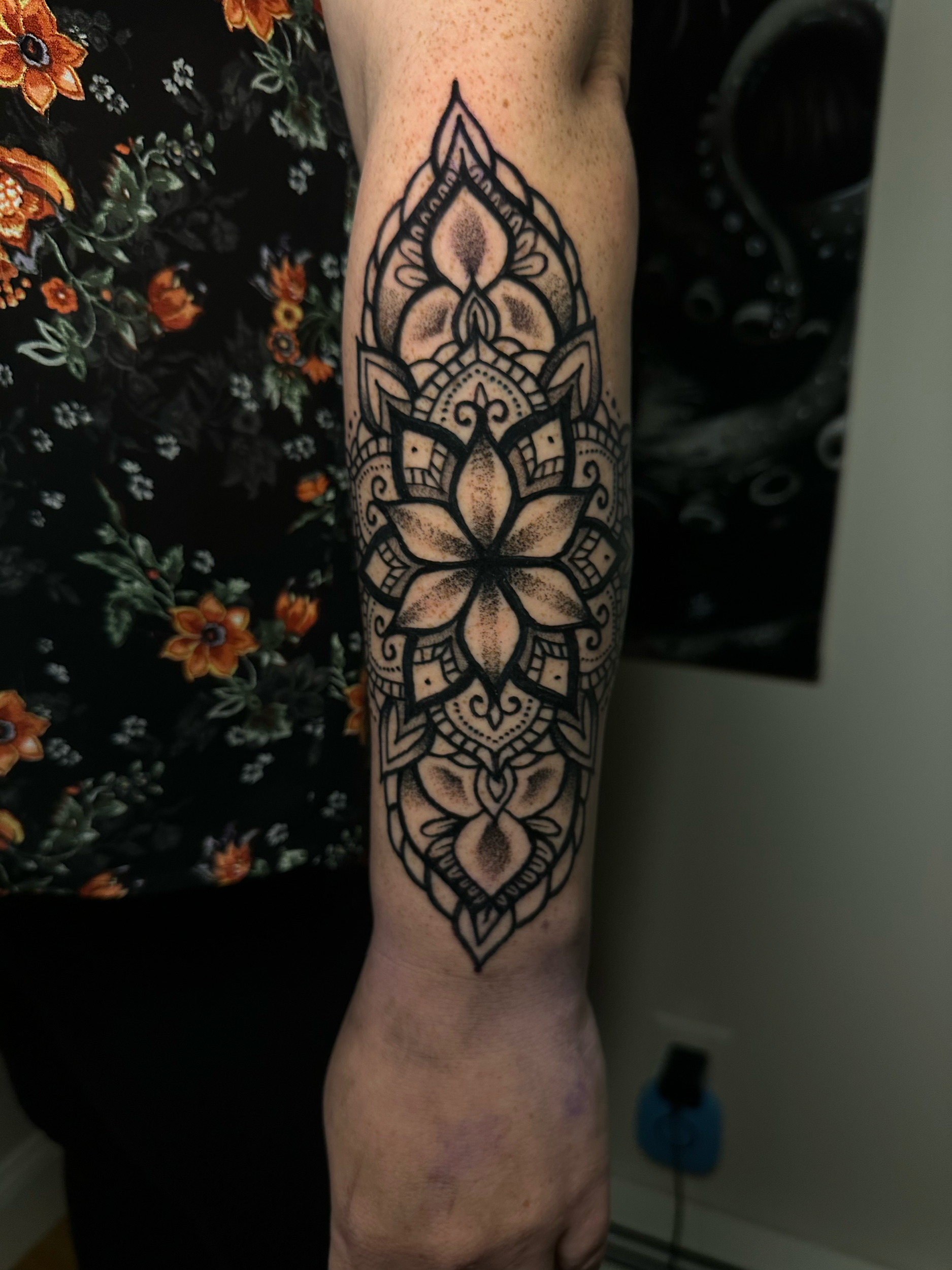 Forearm mandala tattoo with floral and geometric patterns.