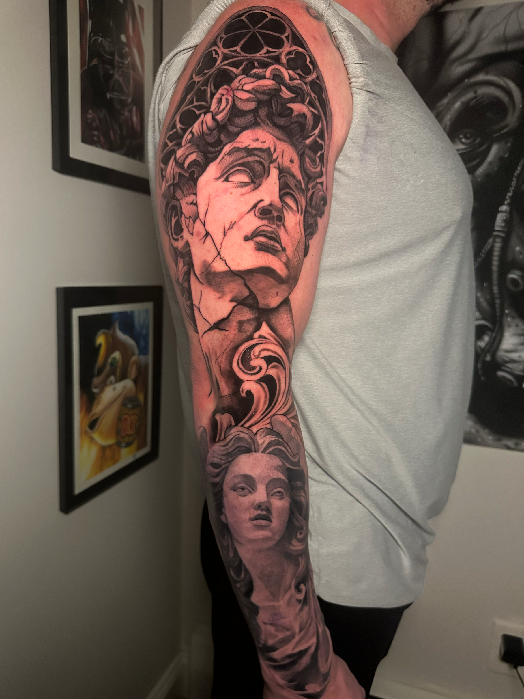 Tattoo sleeve on person's arm featuring a woman's face with flowing hair surrounded by floral patterns and decorative elements.