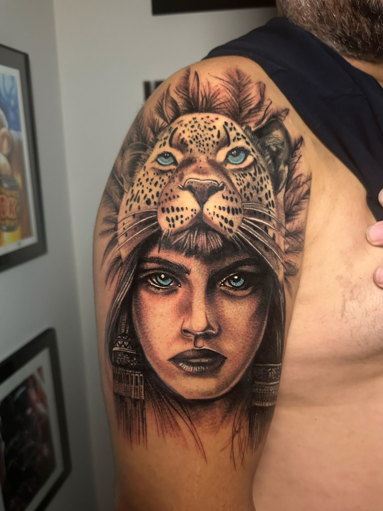 Tattoo of hybrid face with leopard and human on shoulder
