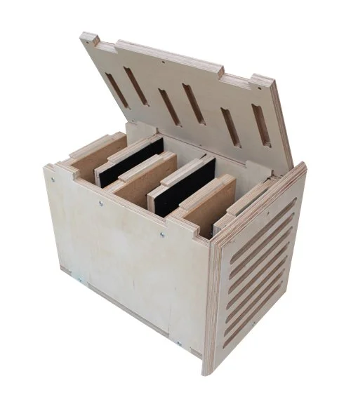 Wooden storage box with a hinged lid, containing slots for organizing cutting boards or similar flat items.