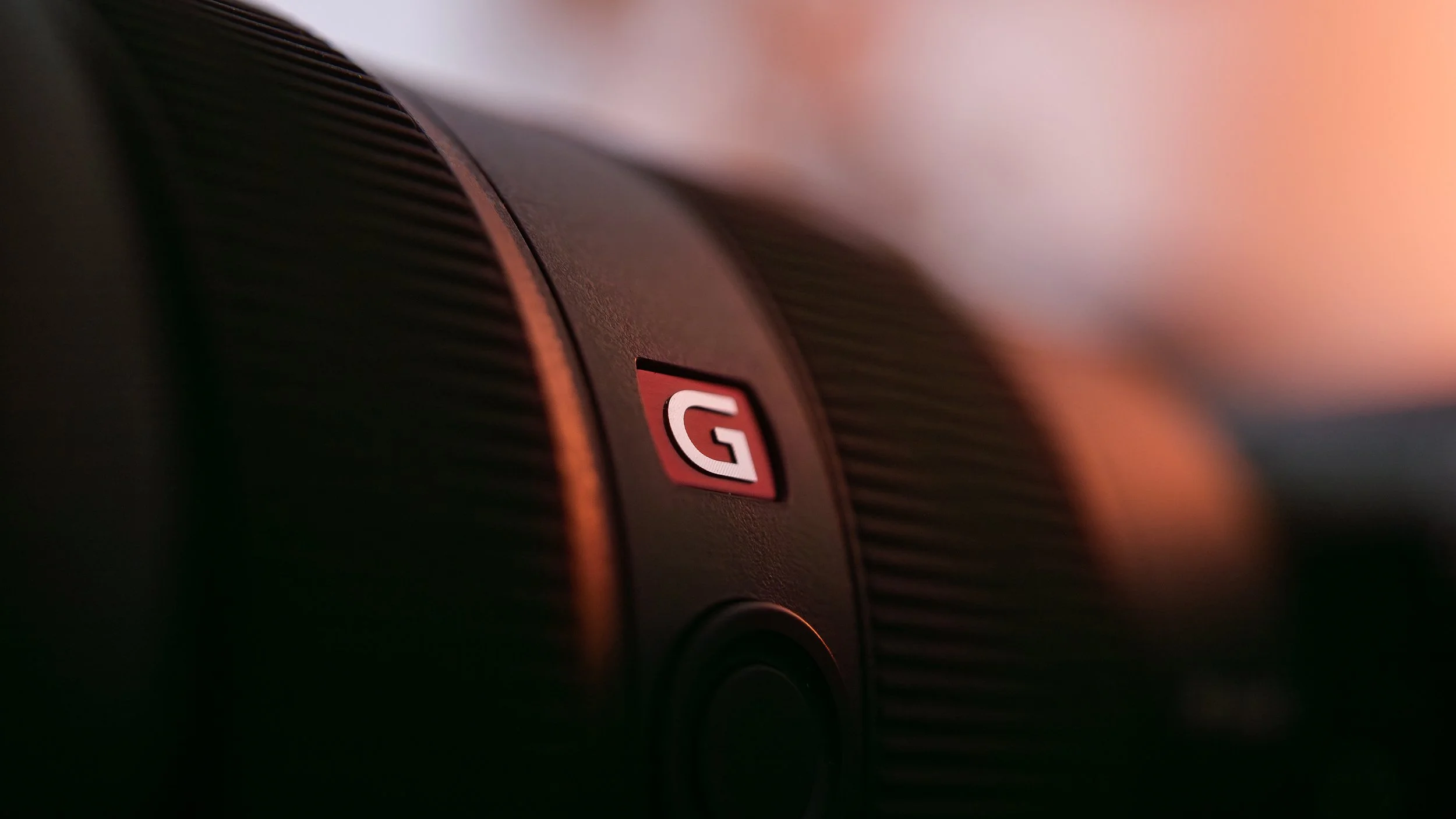 Nahaufnahme eines Kameraobjektivs mit einem roten "G" Symbol.
