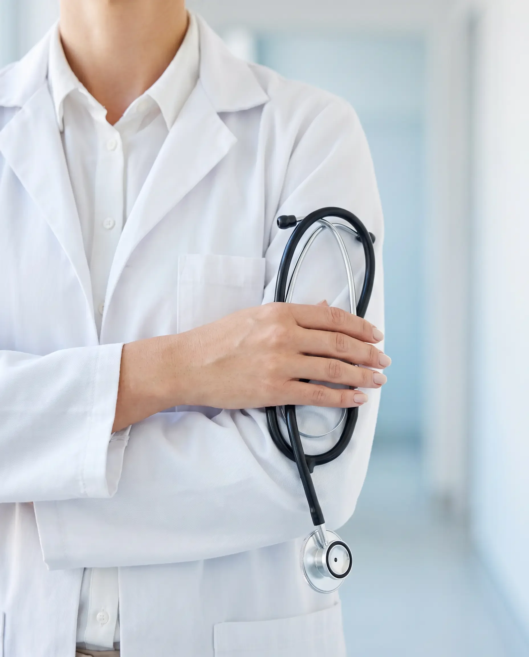 Female physician in a white lab coat holding a stethoscope, women's health care at Concierge Medicine of Cincinnati