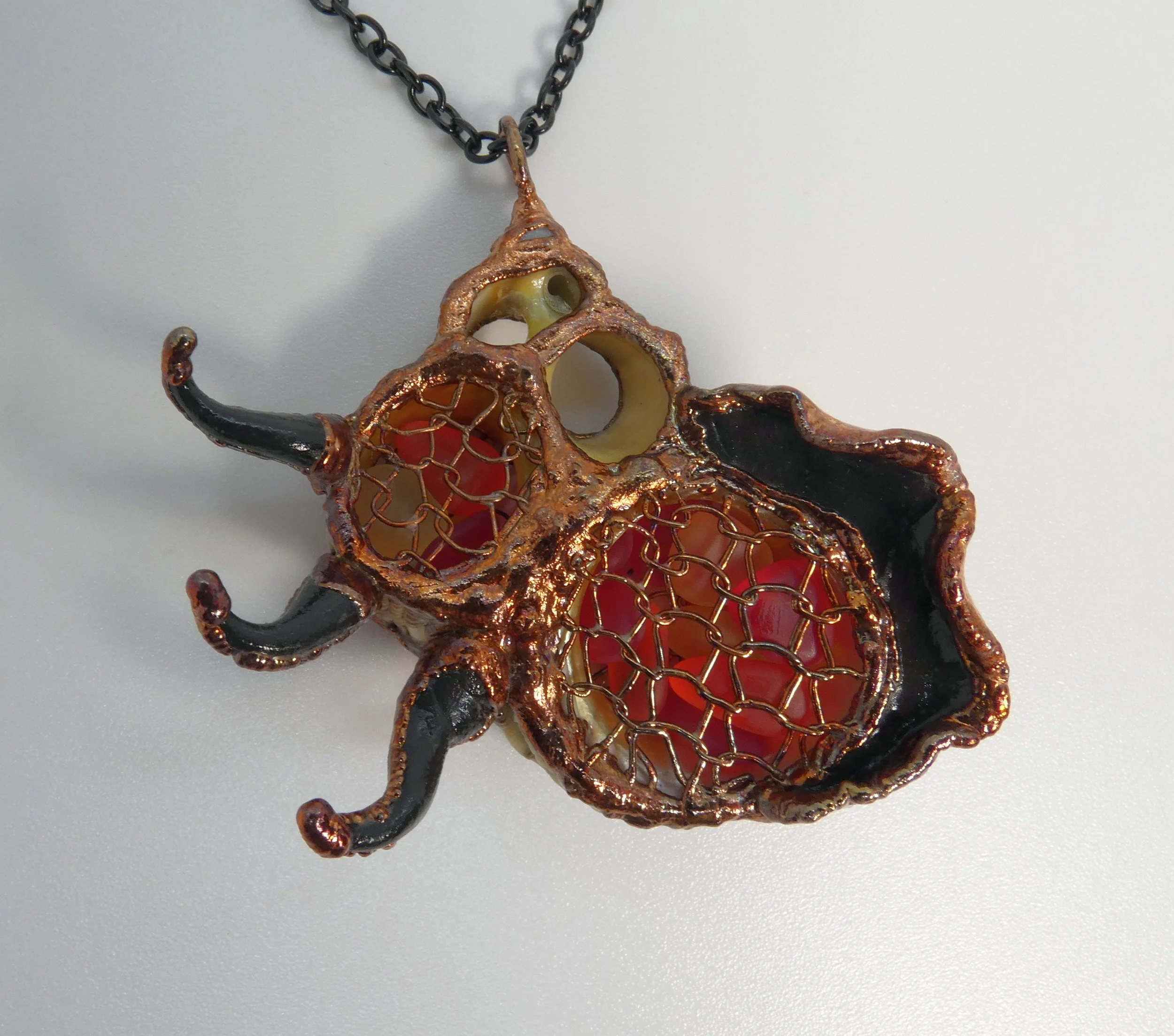 Symbiont 018 (Pendant): seashell slice, tumbled glass, copper mesh, epoxy clay, electroformed in copper. 2.5” H x 2.5” W. Available $250.