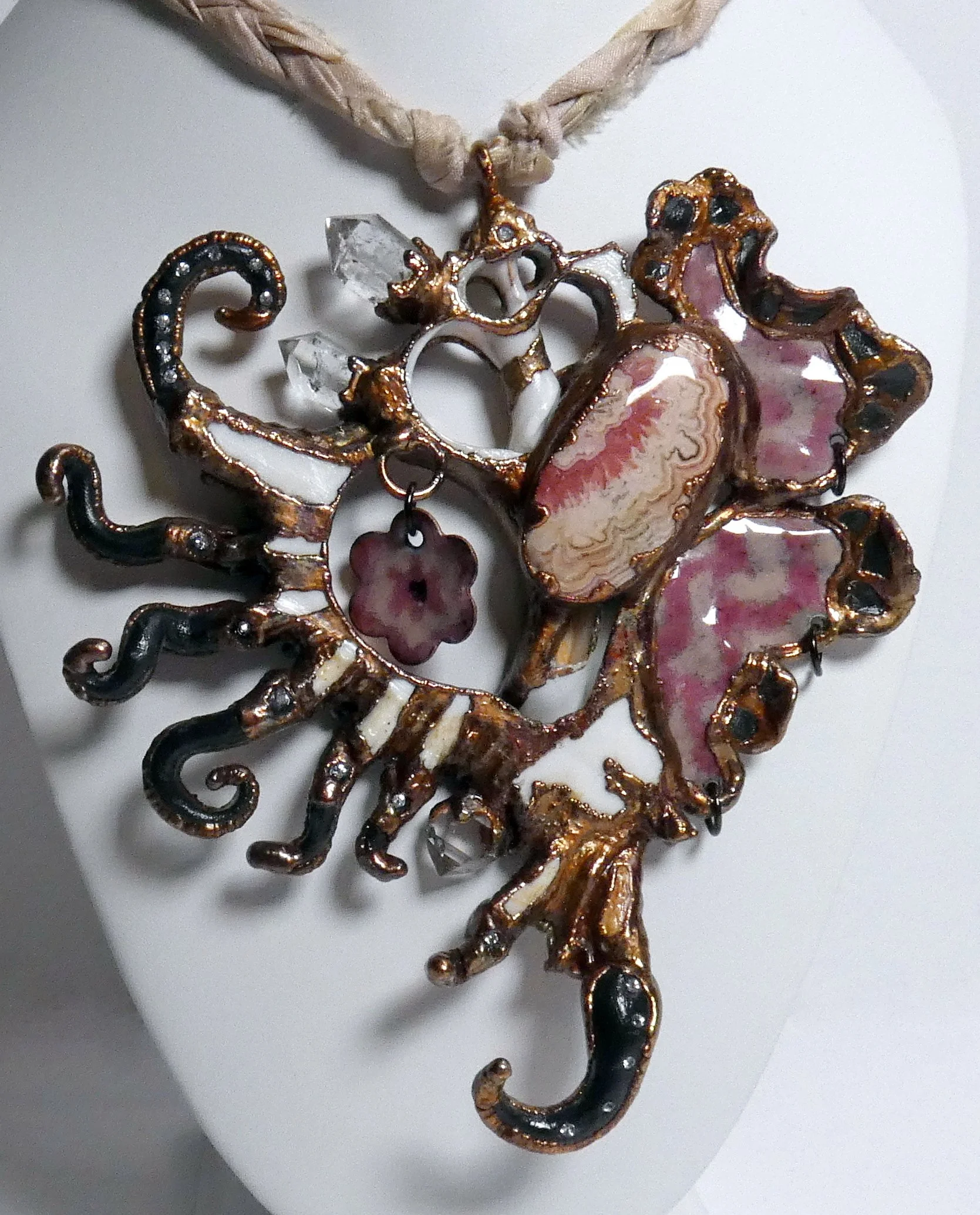 Symbiont 021 (Neckpiece): seashell slice, enameled copper, rhodochrosite, Herkimer diamond quartz points, rhinestones, epoxy clay, electroformed in copper set on braided sari silk with copper chain and wire. 5” H x 4.5” W x adjustable length. Not for